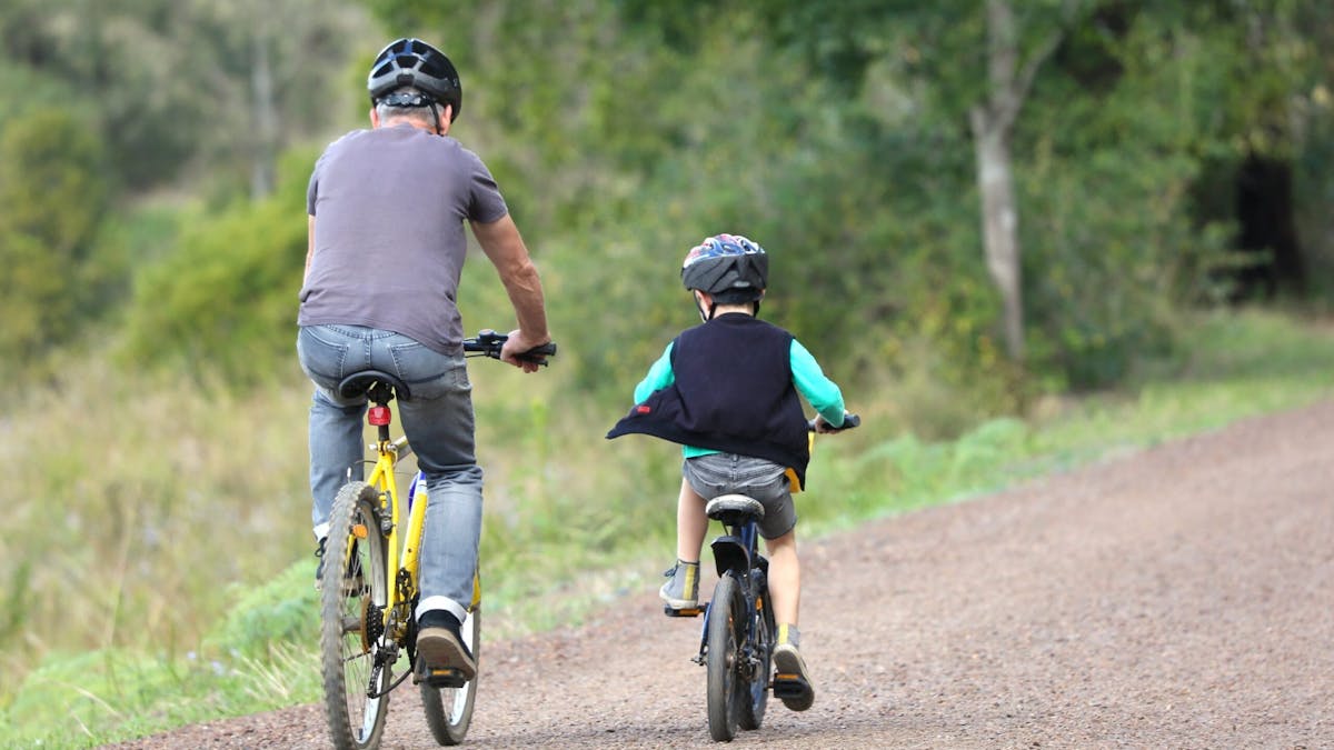 a father and son ride their bikes along the Mary Valley Rail Trail.