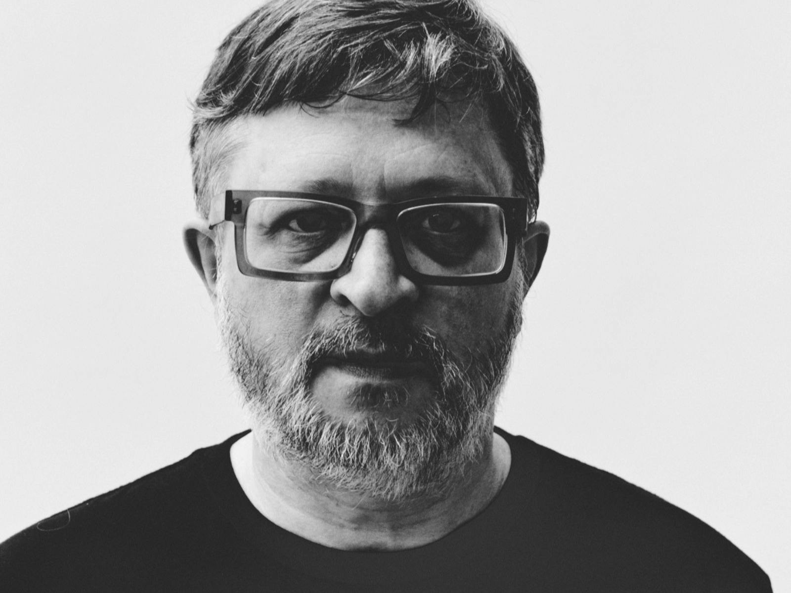 Black and white image of man wearing glasses looking at camera