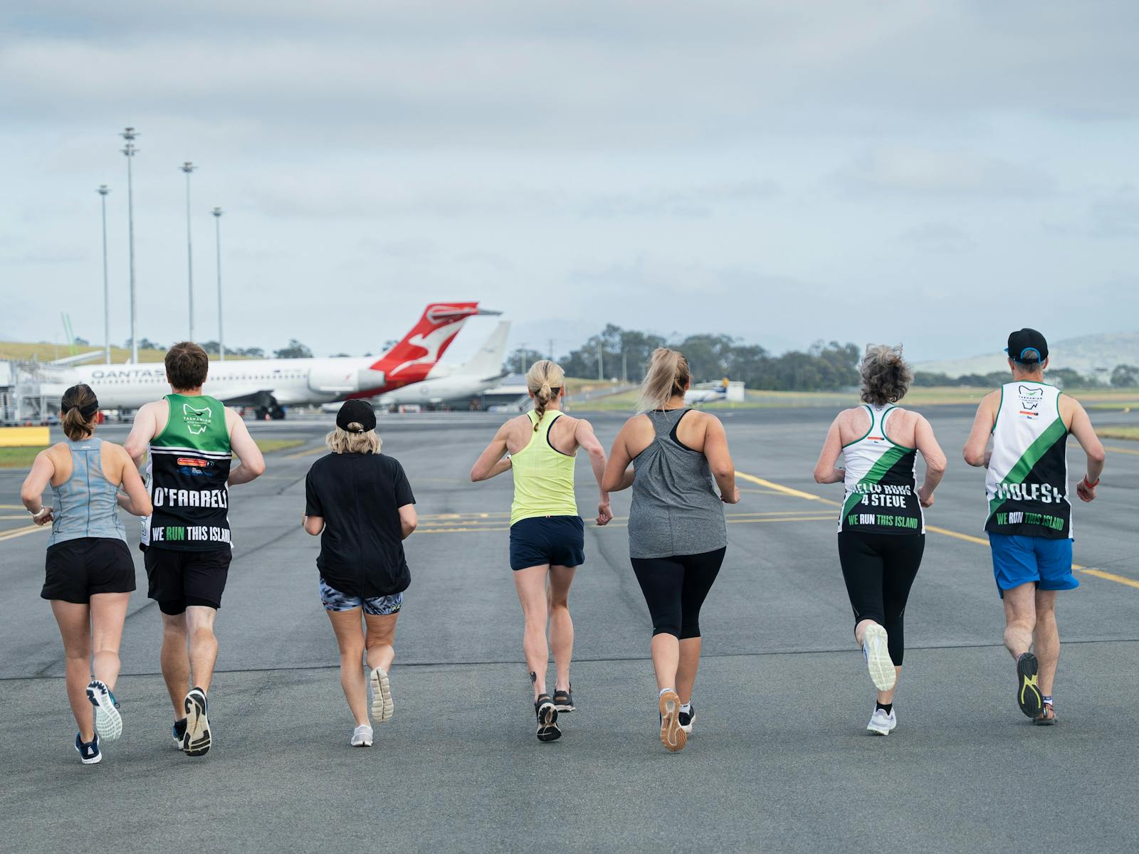 Runners jogging down airport runway