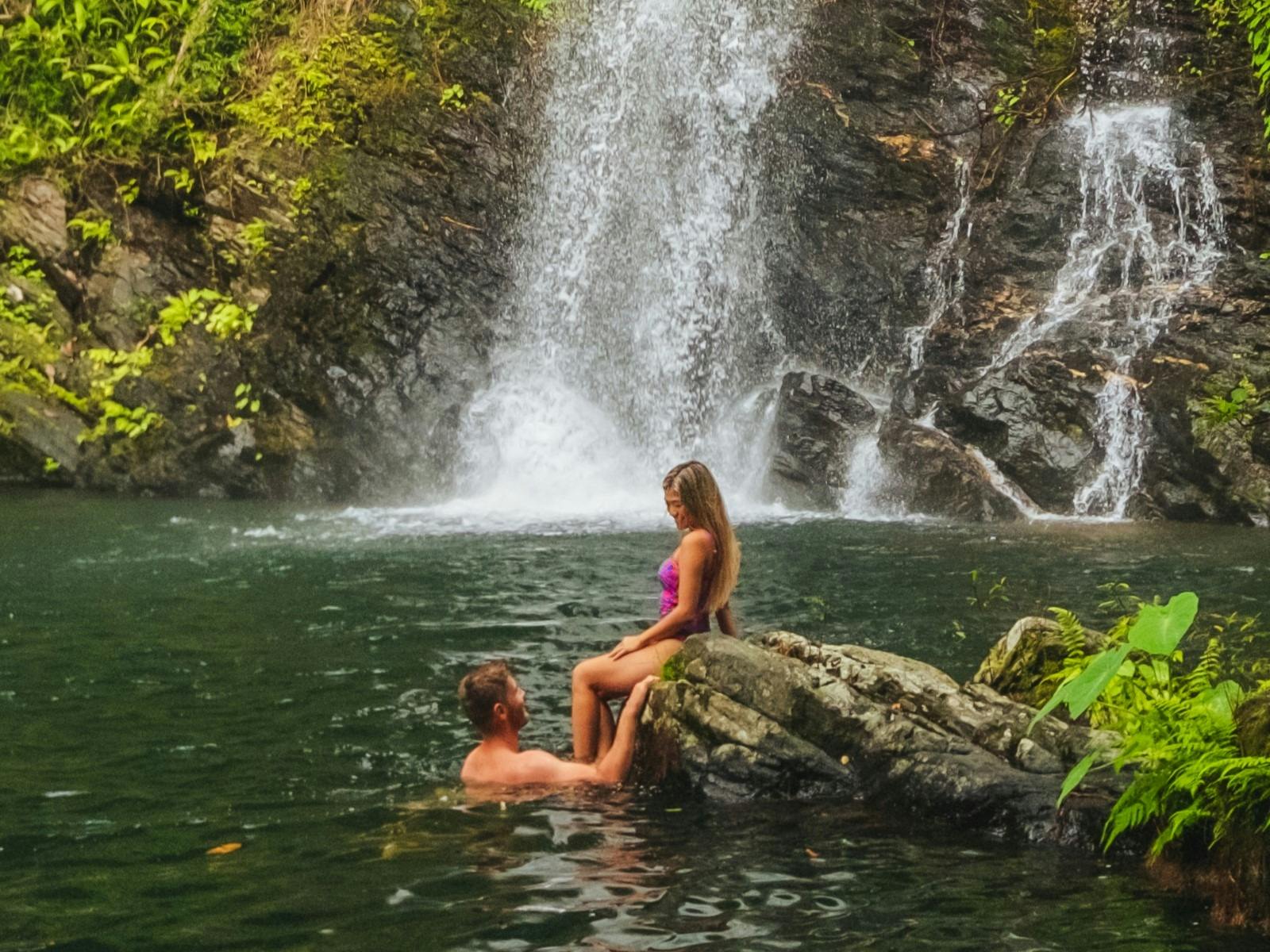 couple in waterfall swimming area couple in waterfall swimming area