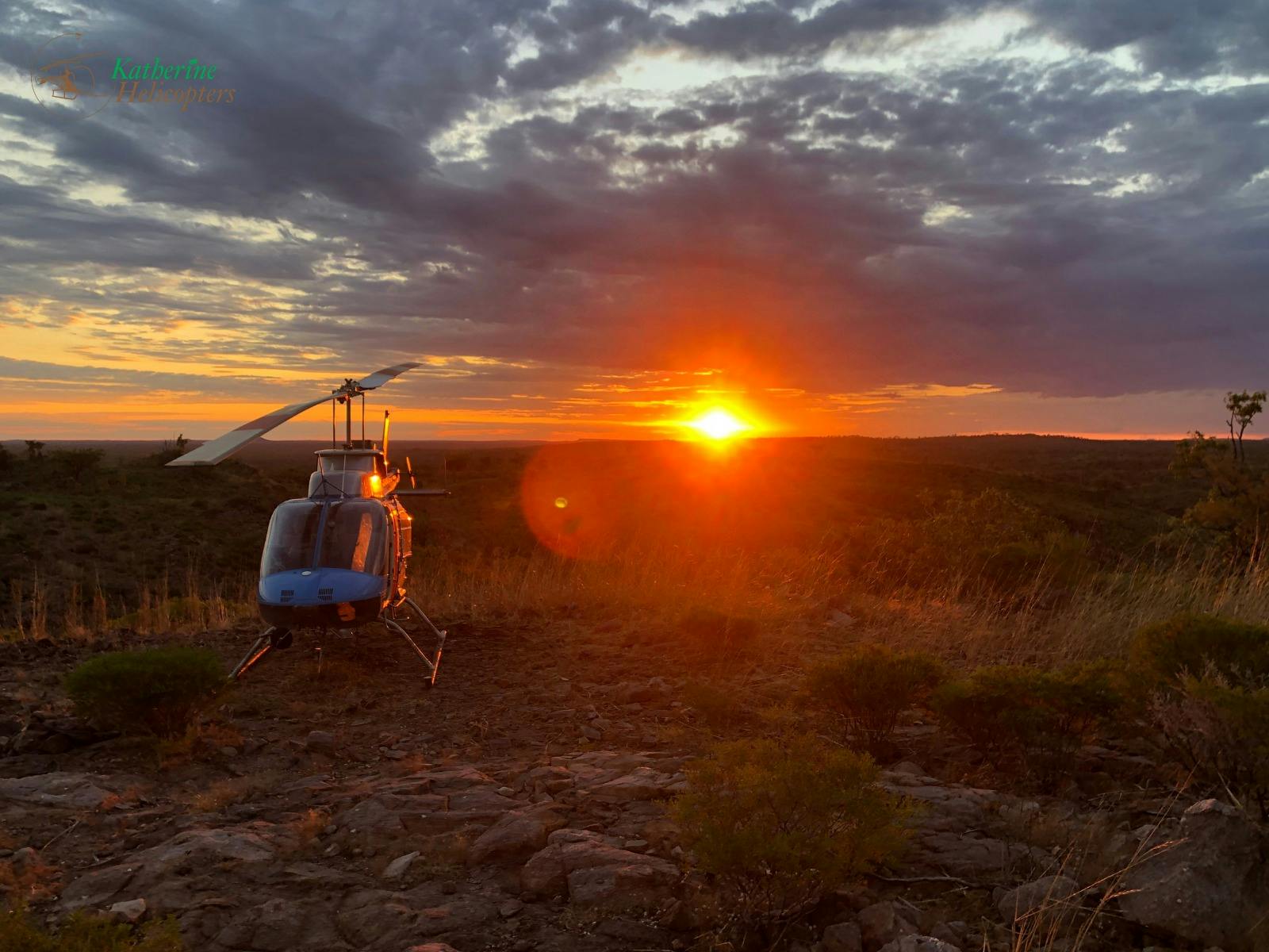 Bell 206 Helicopter parked at remote helipad in the NT with sunset