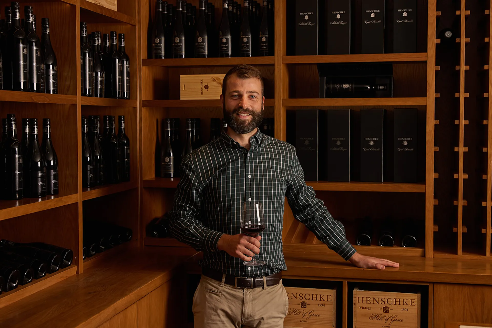 A picture of Andreas Henschke holding a glass of wine