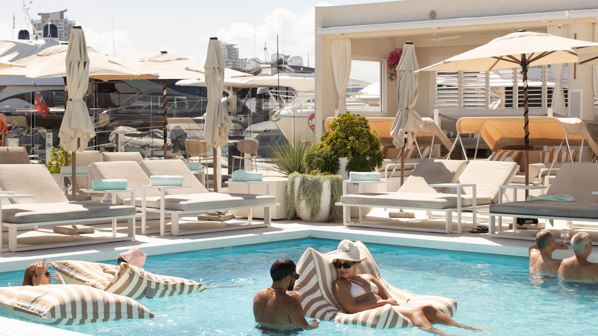 Busy poolside atmosphere at La Luna Beach Club overlooking the marina