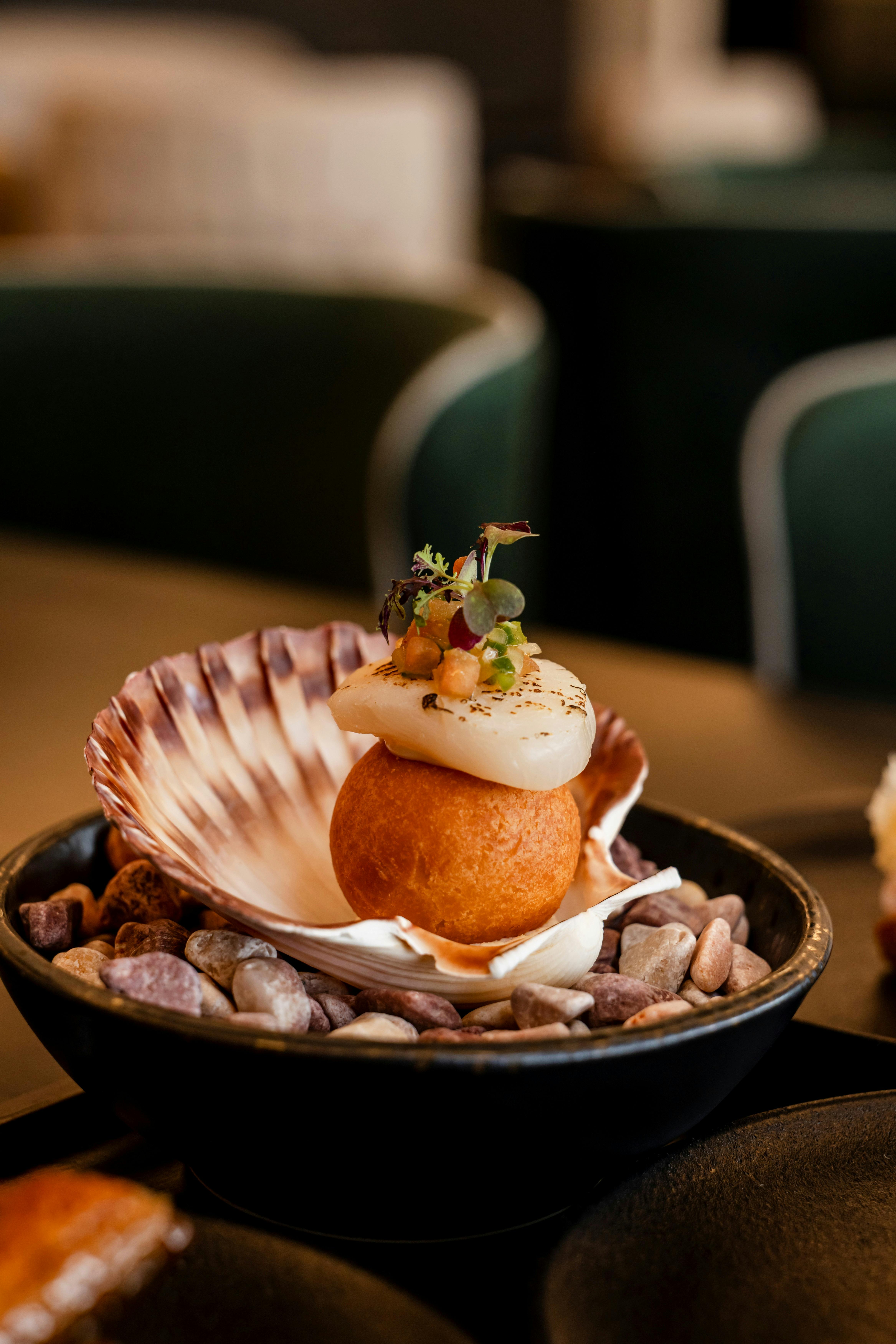 Pecorino donut resting in a scallop shell topped with creme fraiche