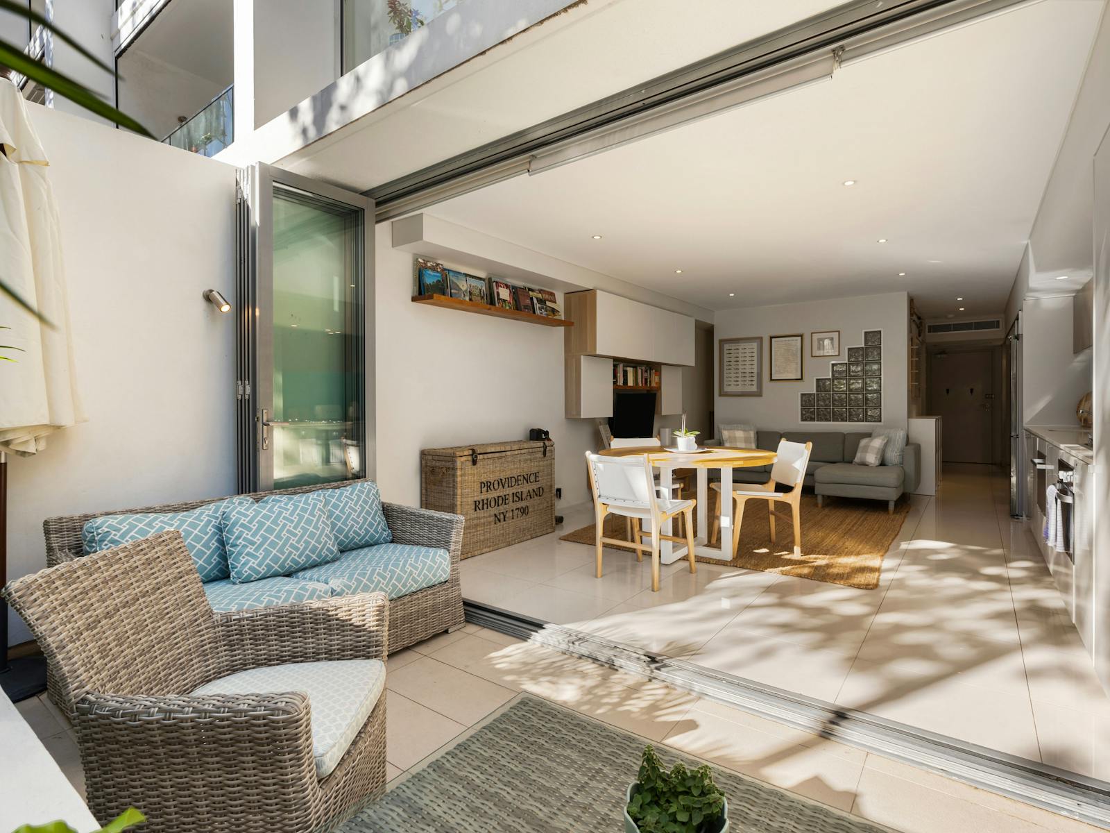 Modern kitchen and living space with a turquoise splashback and a cozy private courtyard.