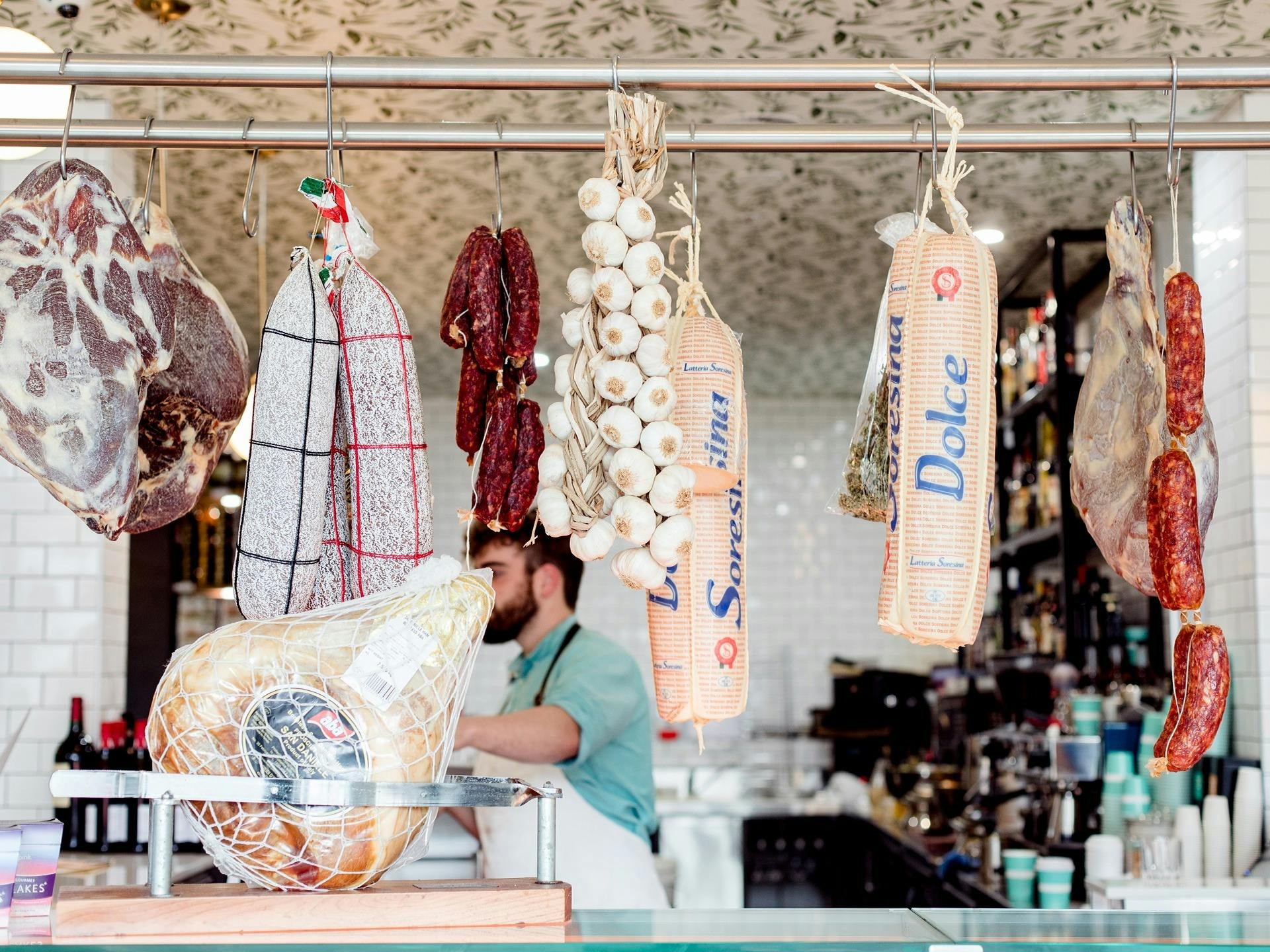 Traditional Italian style cured meats hanging in a delicatessen.