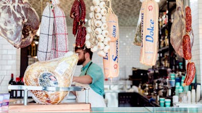 Traditional Italian style cured meats hanging in a delicatessen.
