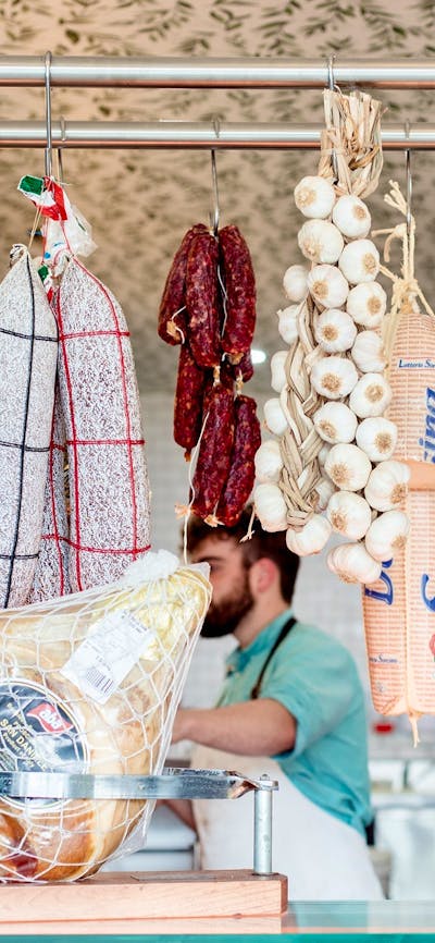 Traditional Italian style cured meats hanging in a delicatessen.