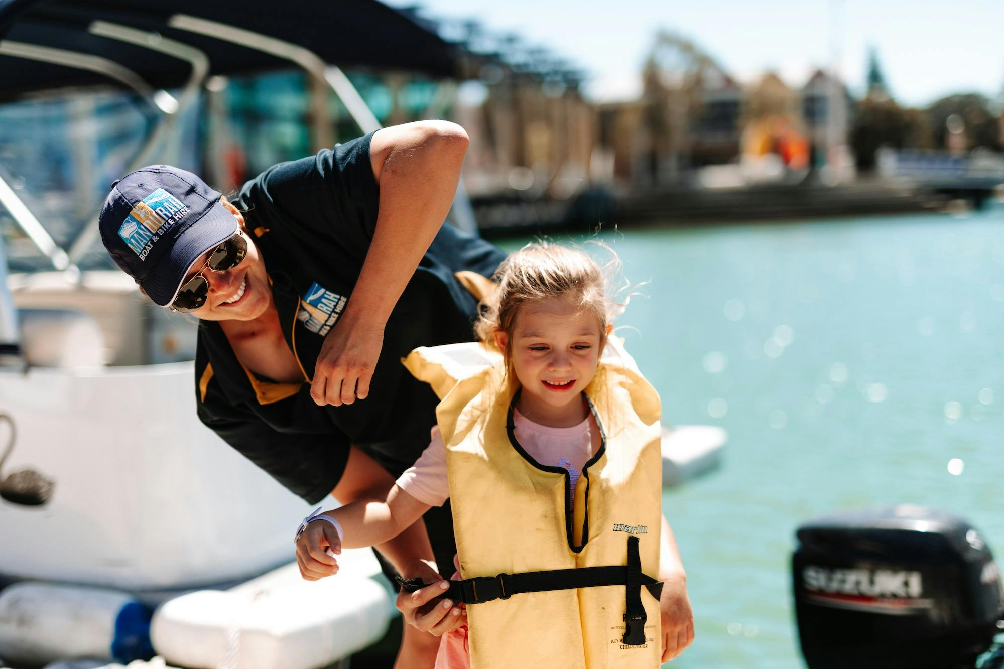 Little girl putting on a life jacket