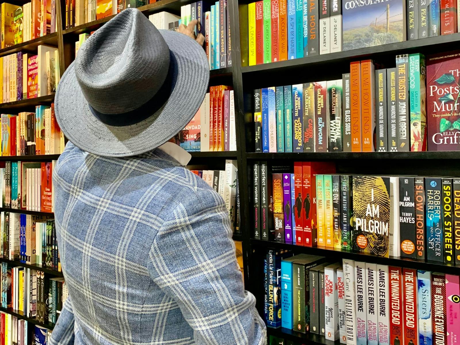 man in a hat browsing the shelves at Woollahra Bookshop