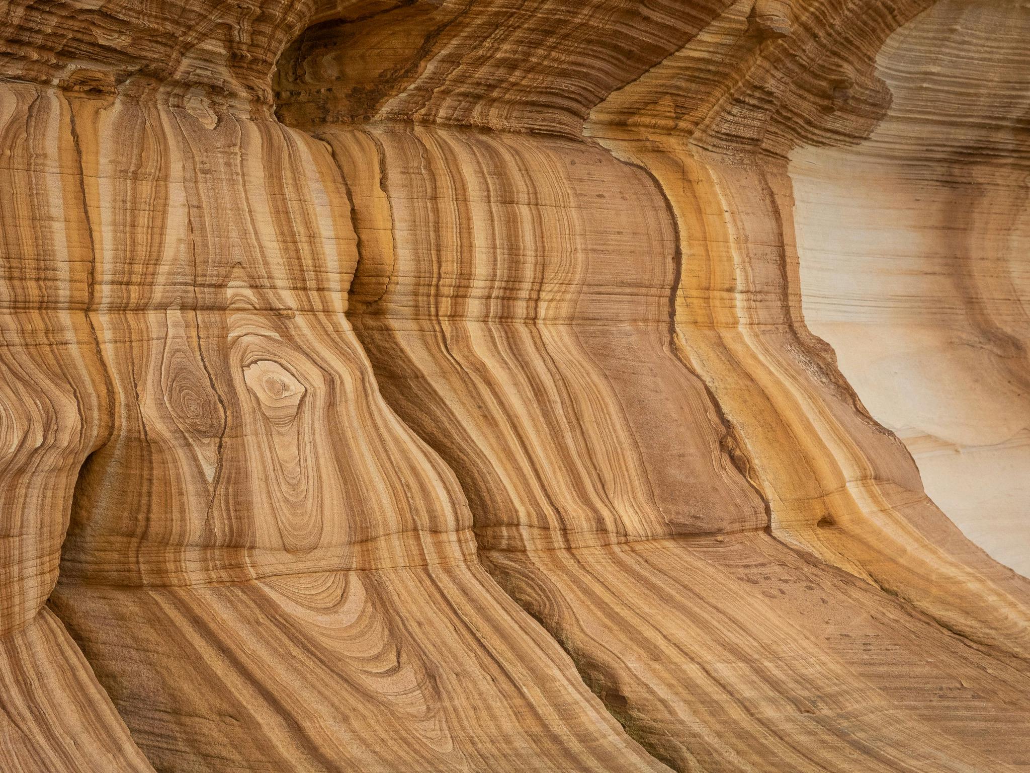 sandstone cliff face with vibrant patterns and shaping patterns etched in time