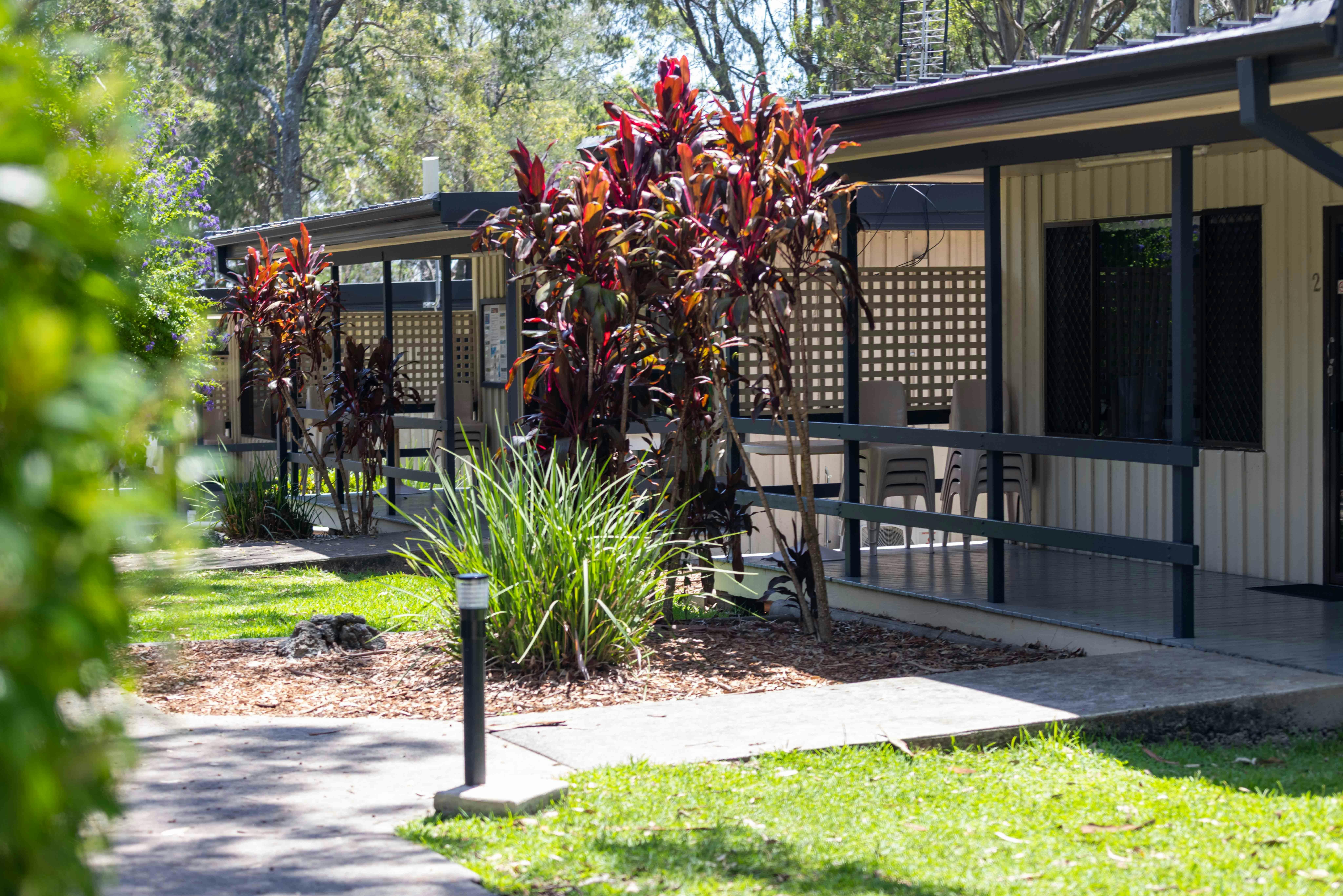 Small cottages with verandahs surrounded by native plants and trees