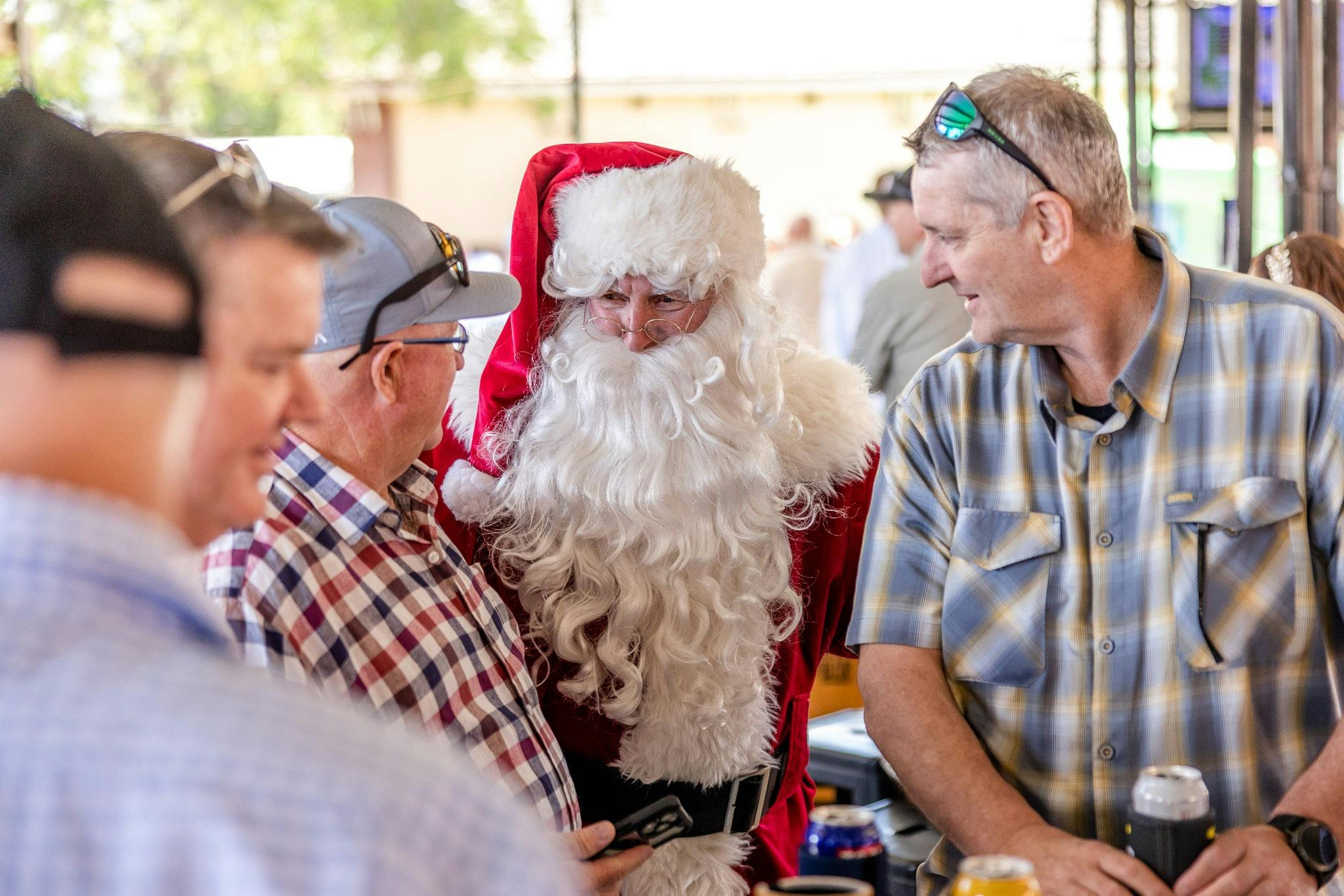 Two men speaking with Santa at a race day