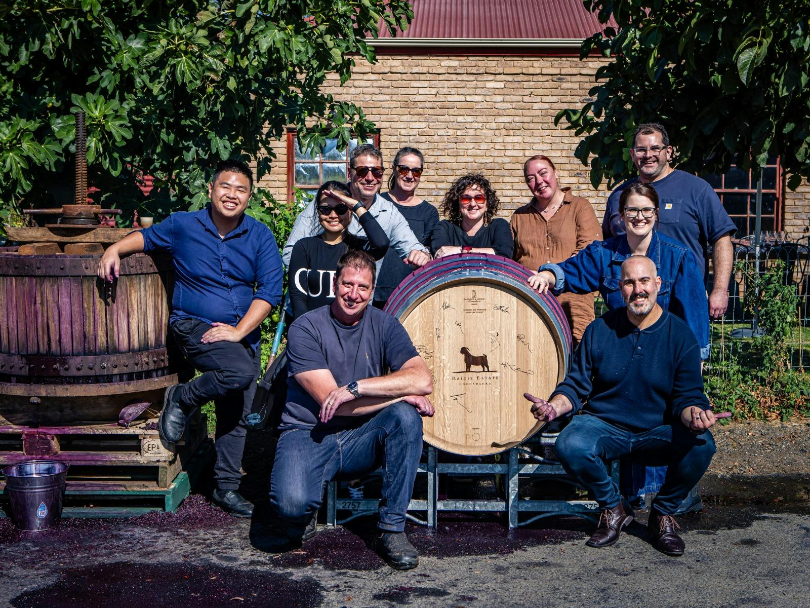 Living the Dream participants smiling in a group photo with a signed barrel