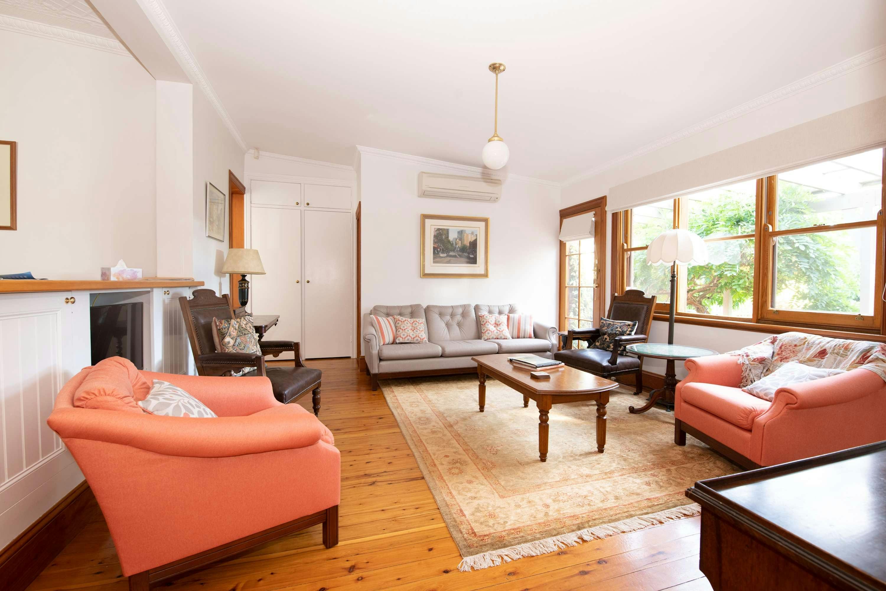 Multiple different armchairs, antique furniture, wooden floors, aircon, and tv