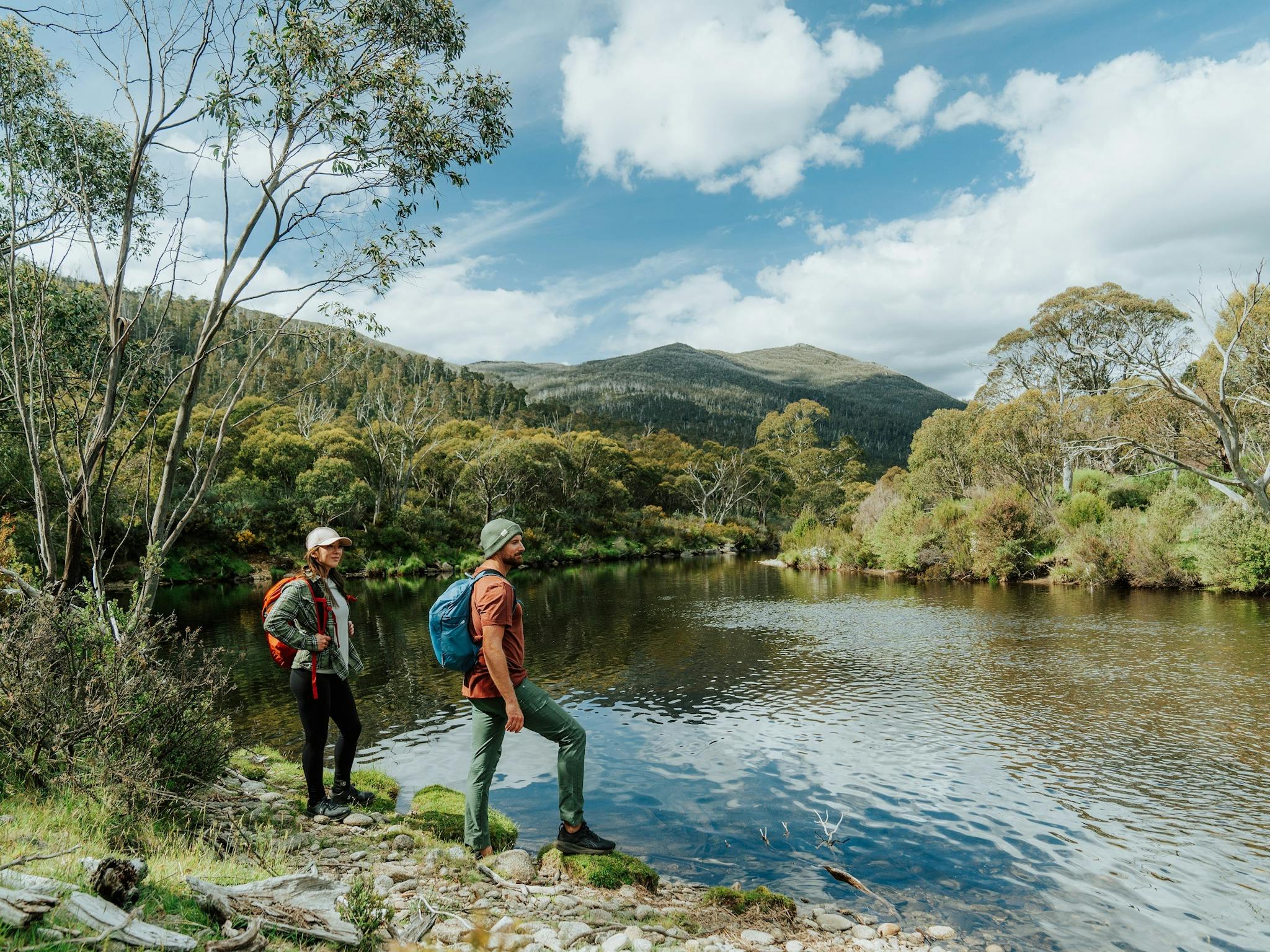 Two hikers taking in the serenity of Thredbo River.
