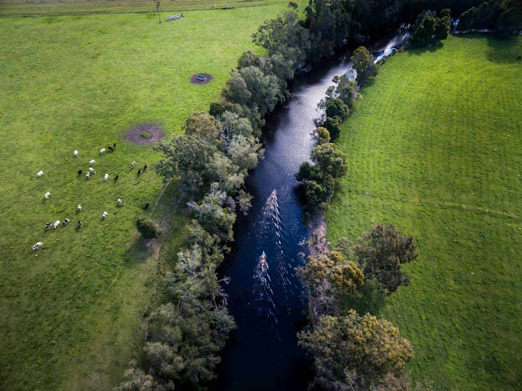 Aerial view of two kayaks on a river surrounded by farm land