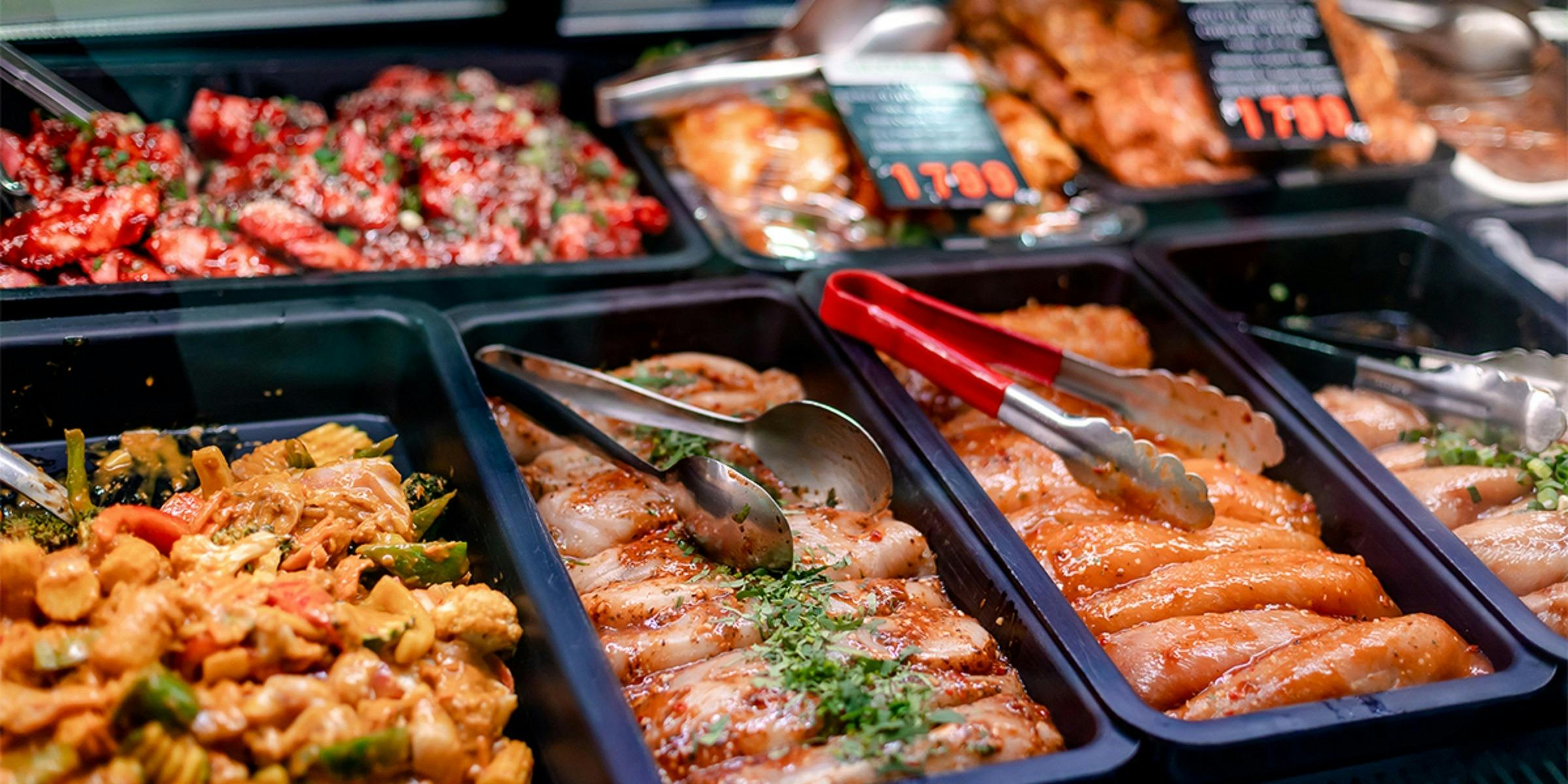Trays of chicken with tongs