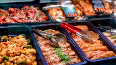 Trays of chicken with tongs