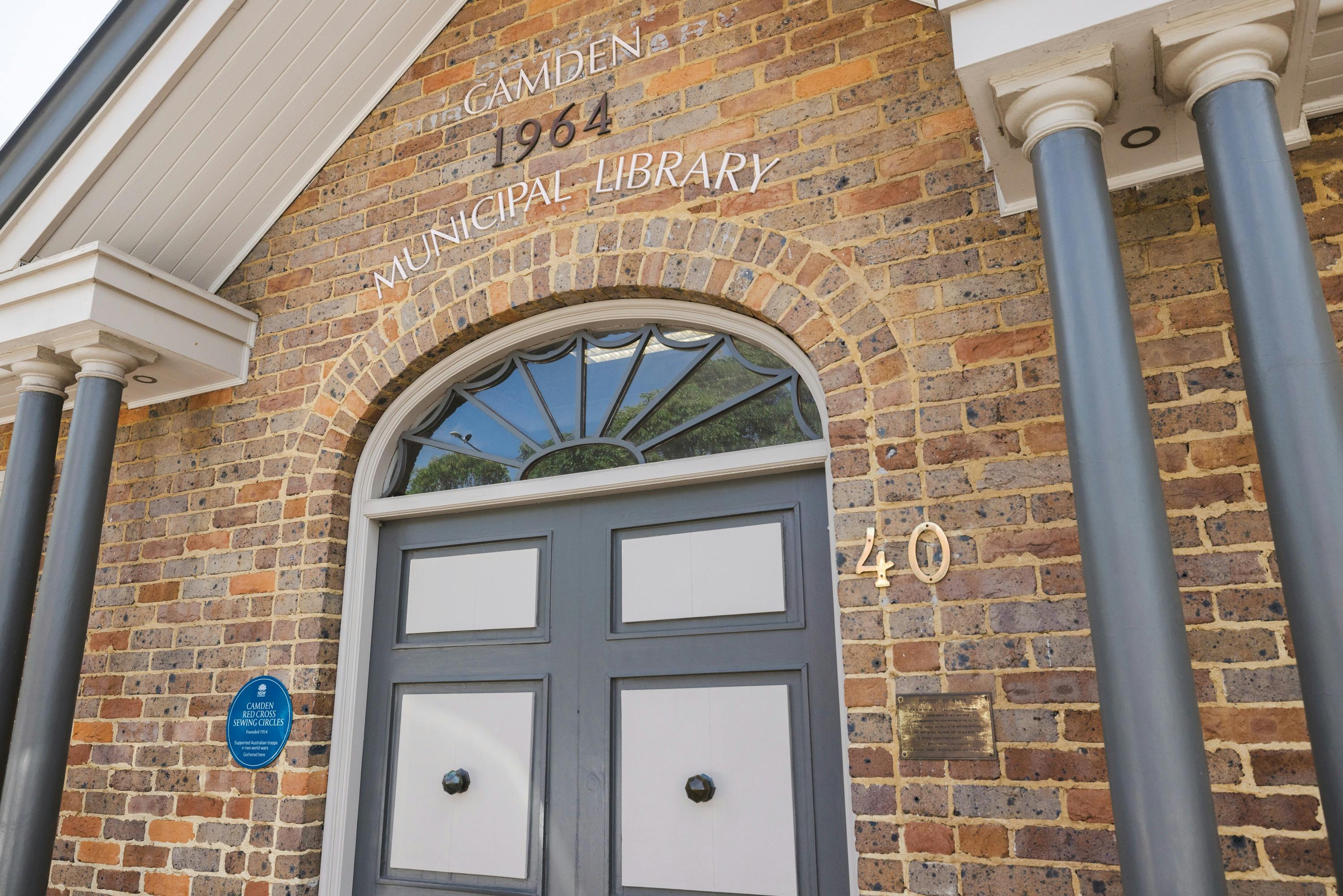 Blue Plaque next to door.  Writing on building says "Camber 1964 Municipal Library" and "40"