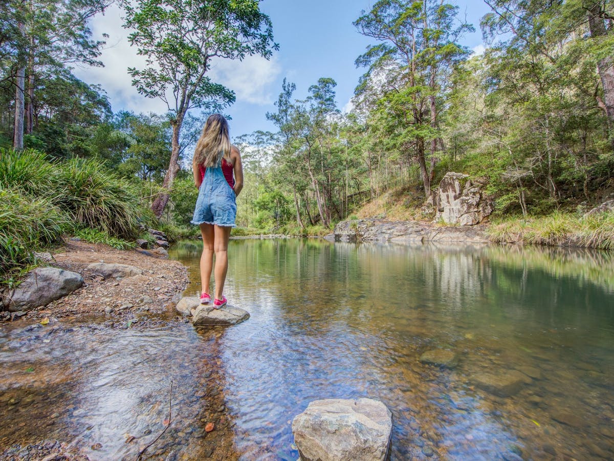 Young girl standing on a rock overlooking the water at Stony Creek