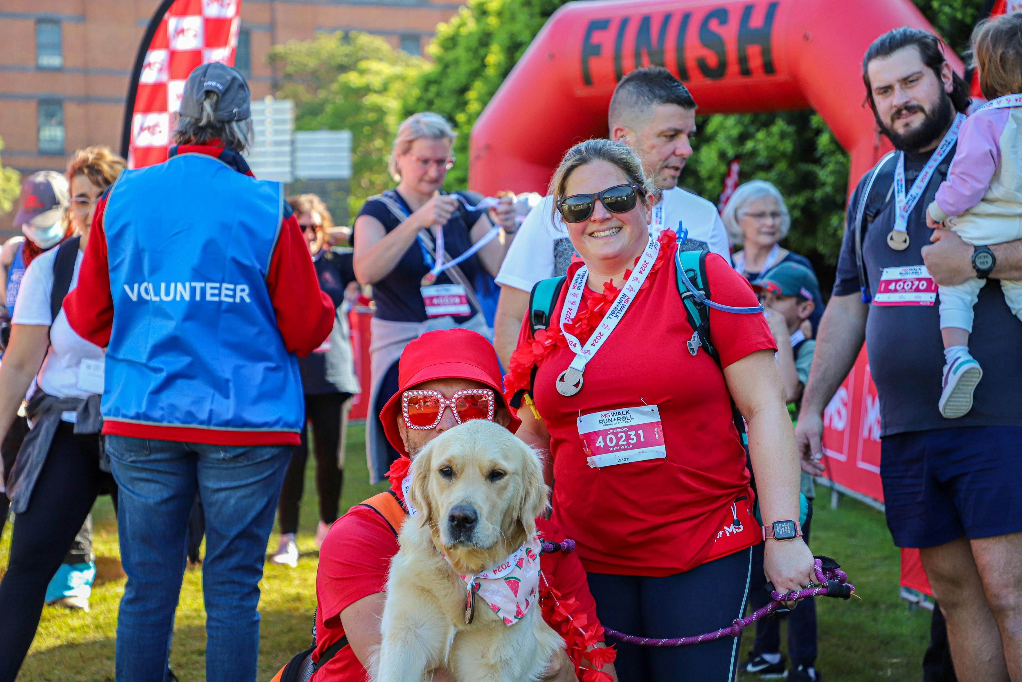 two people in red with their dog