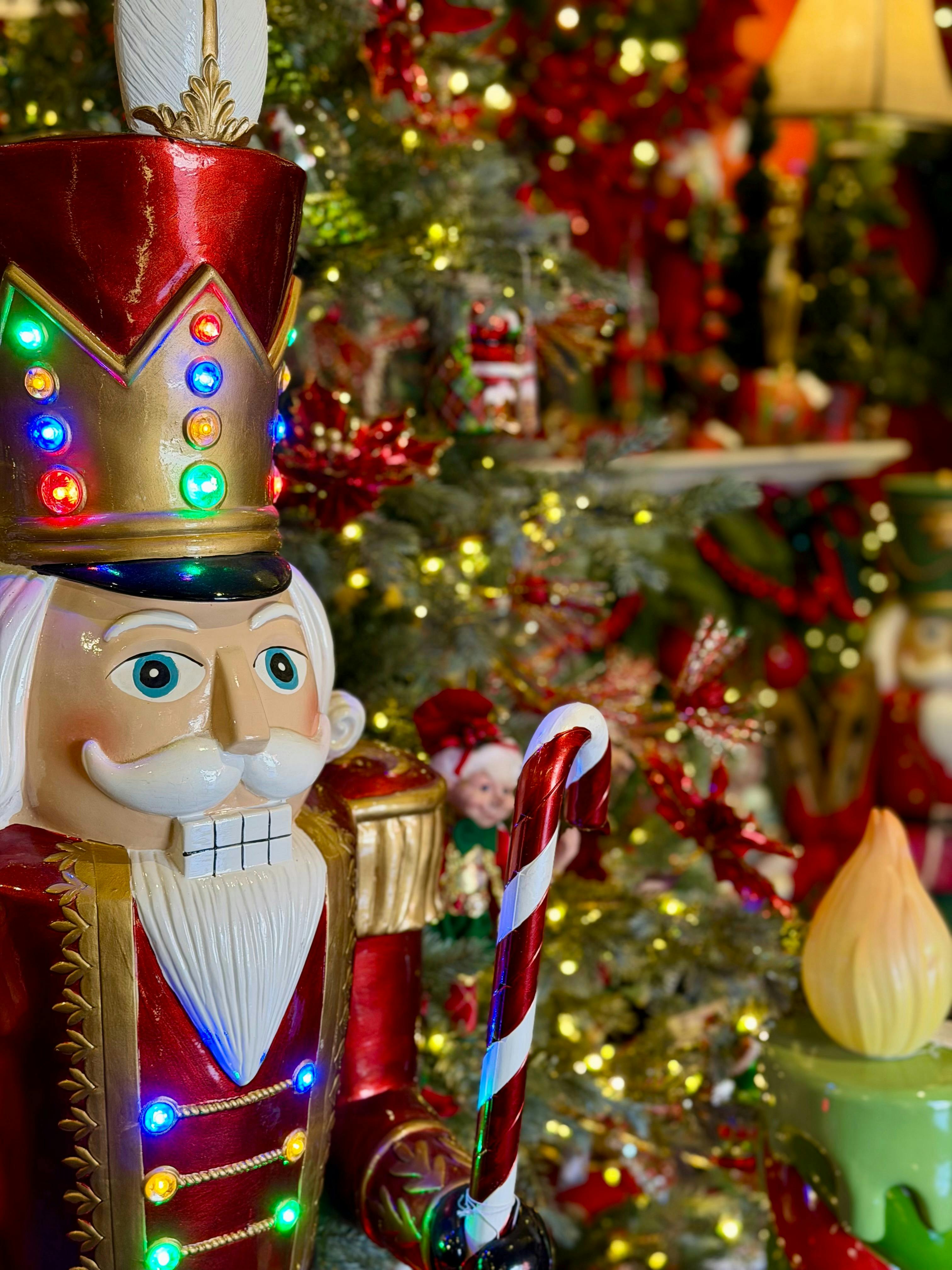 A large light up nutcracker standing in front of a tree