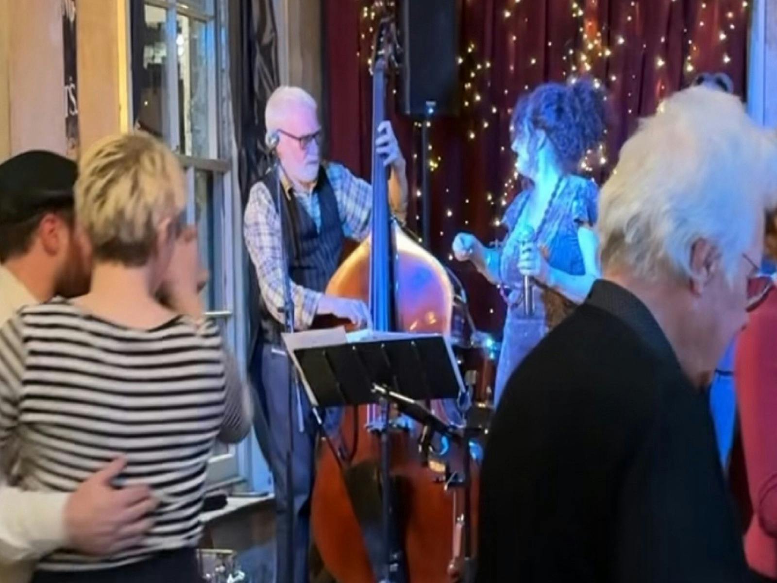 ldoubel bass player and singer in background with foreground of dancers