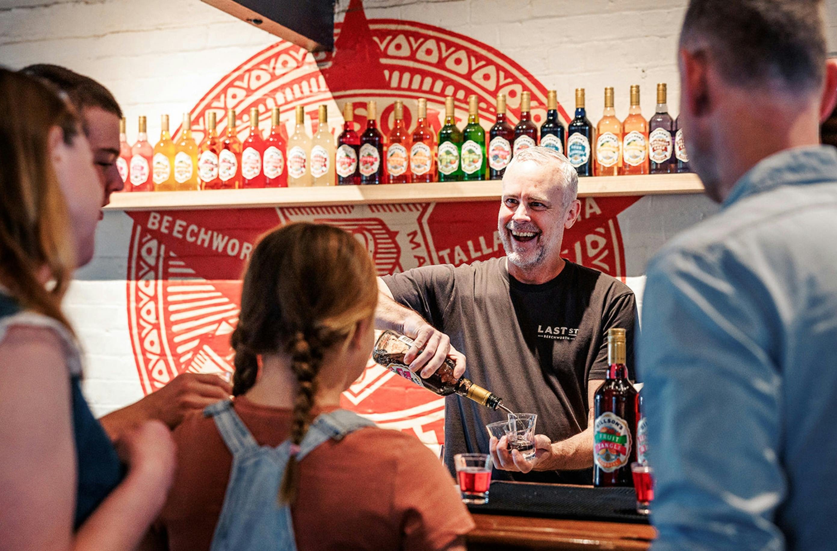 a bartender smiling while pouring drinks at Last St Brewery