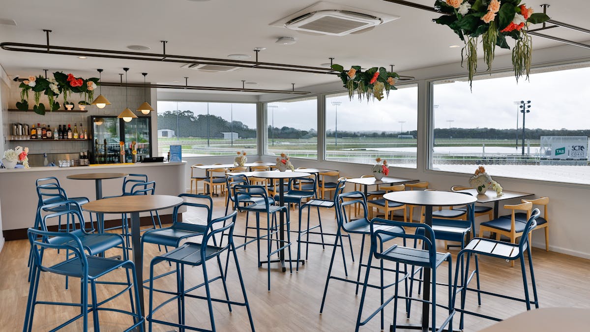 Venue function room with high top tables and bar overlooking the  race track