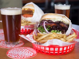 Beer and two burgers with chips