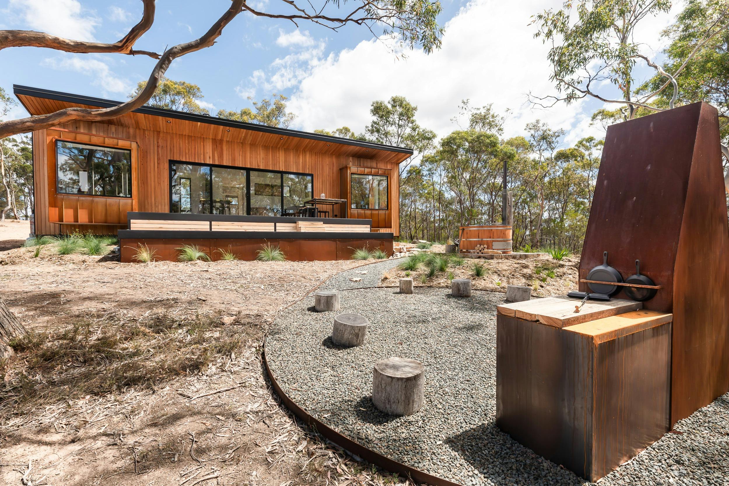Wooden cabin in bush with deck, fire pit and hot tub.