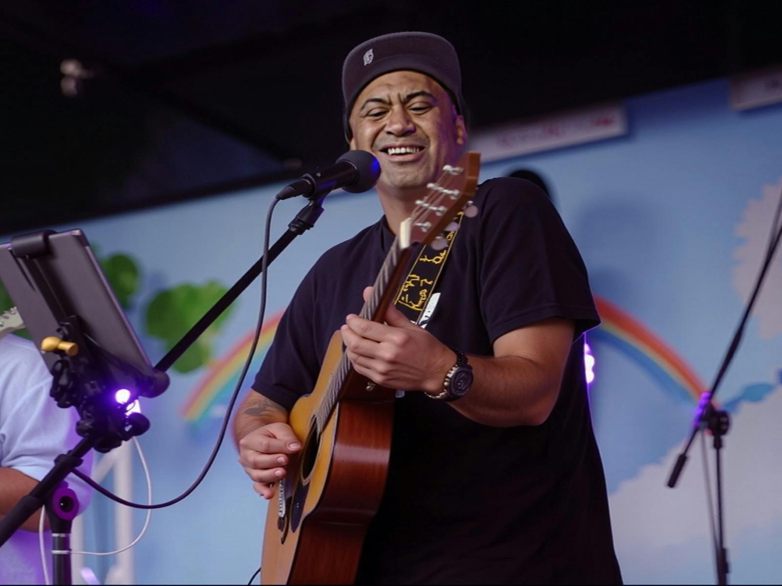 Tama K playing a guitar.