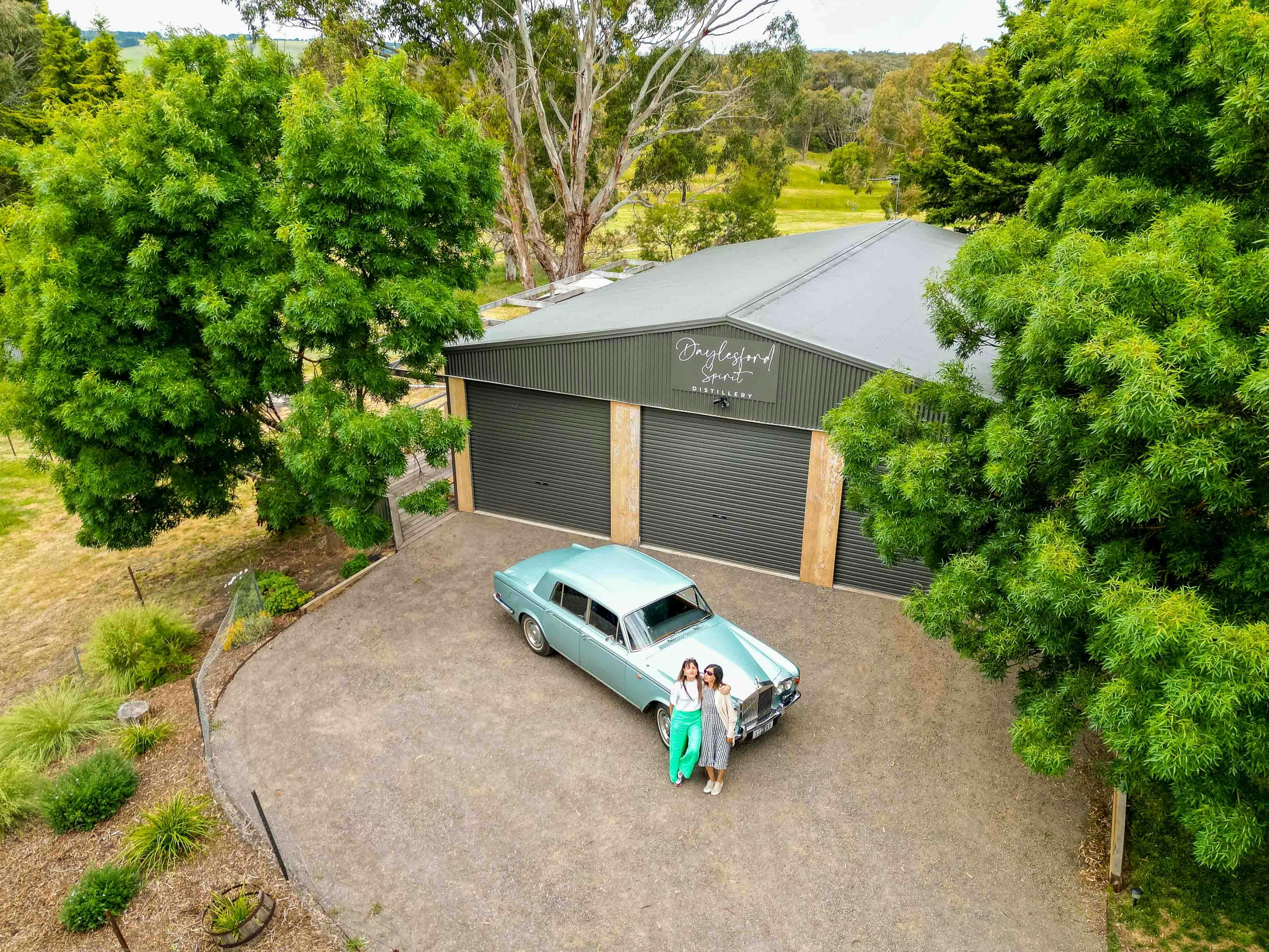 A birds eye view of the silver-blue coloured Rolls Royce car under the Daylesford Spirit sign.