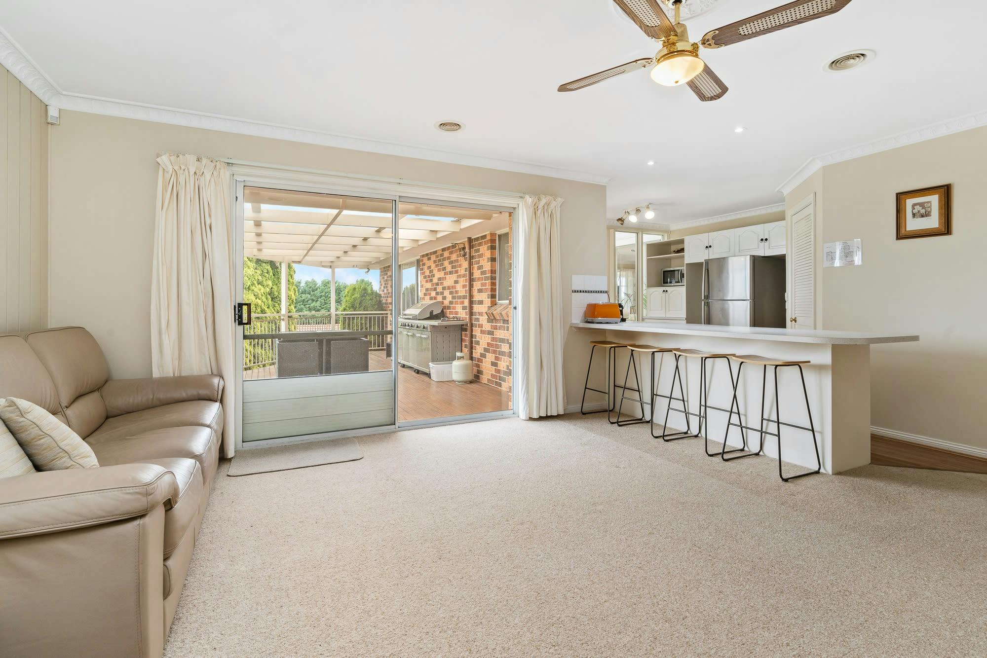 Bar with bar stools and sliding door to the deck