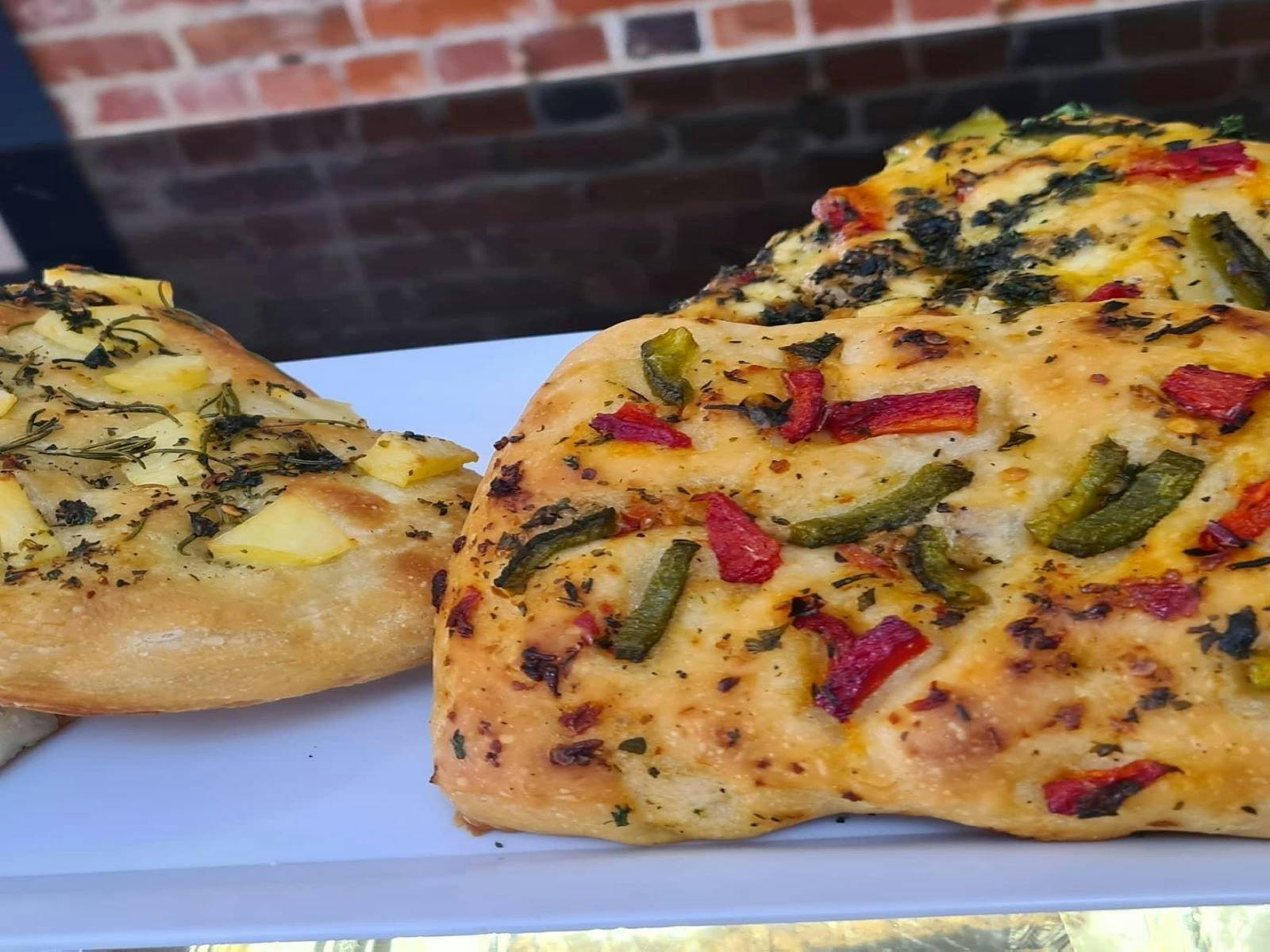 Two different flavoured bread rolls, one with capsicum and tomato and the other spinach and cheese.