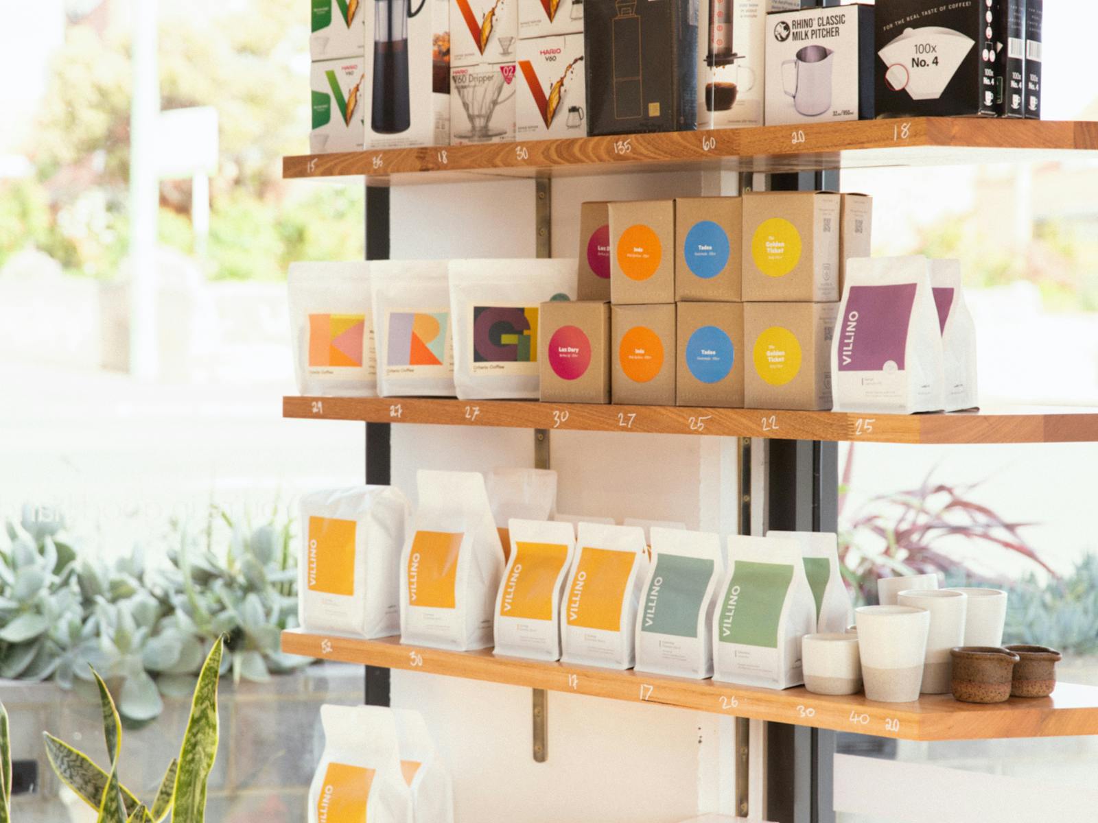 Timber shelves lined with an array of brightly coloured products for sale such as coffee beans.