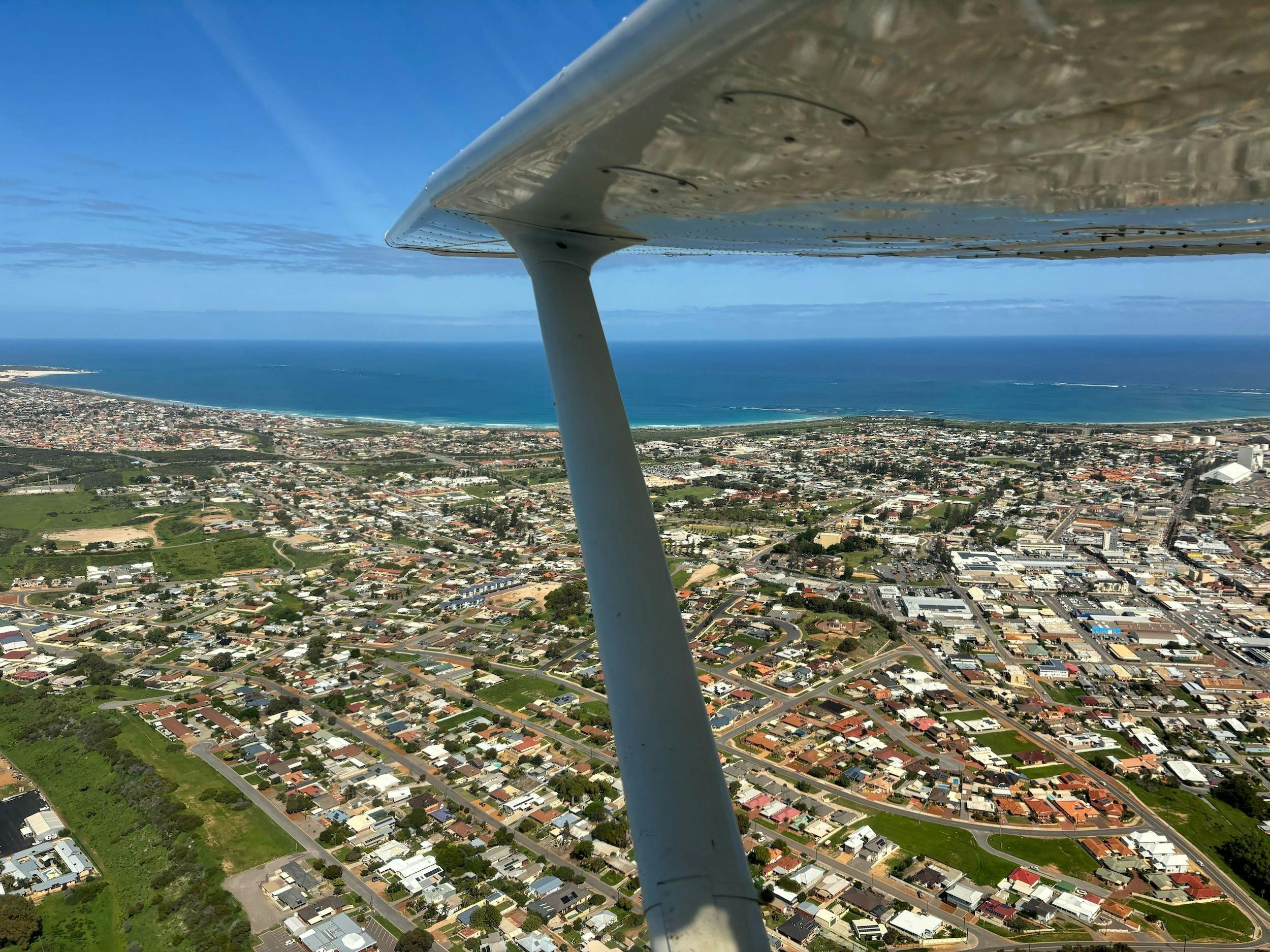 Arial photography of the port town of Geraldton through the window of a high wing aircraft