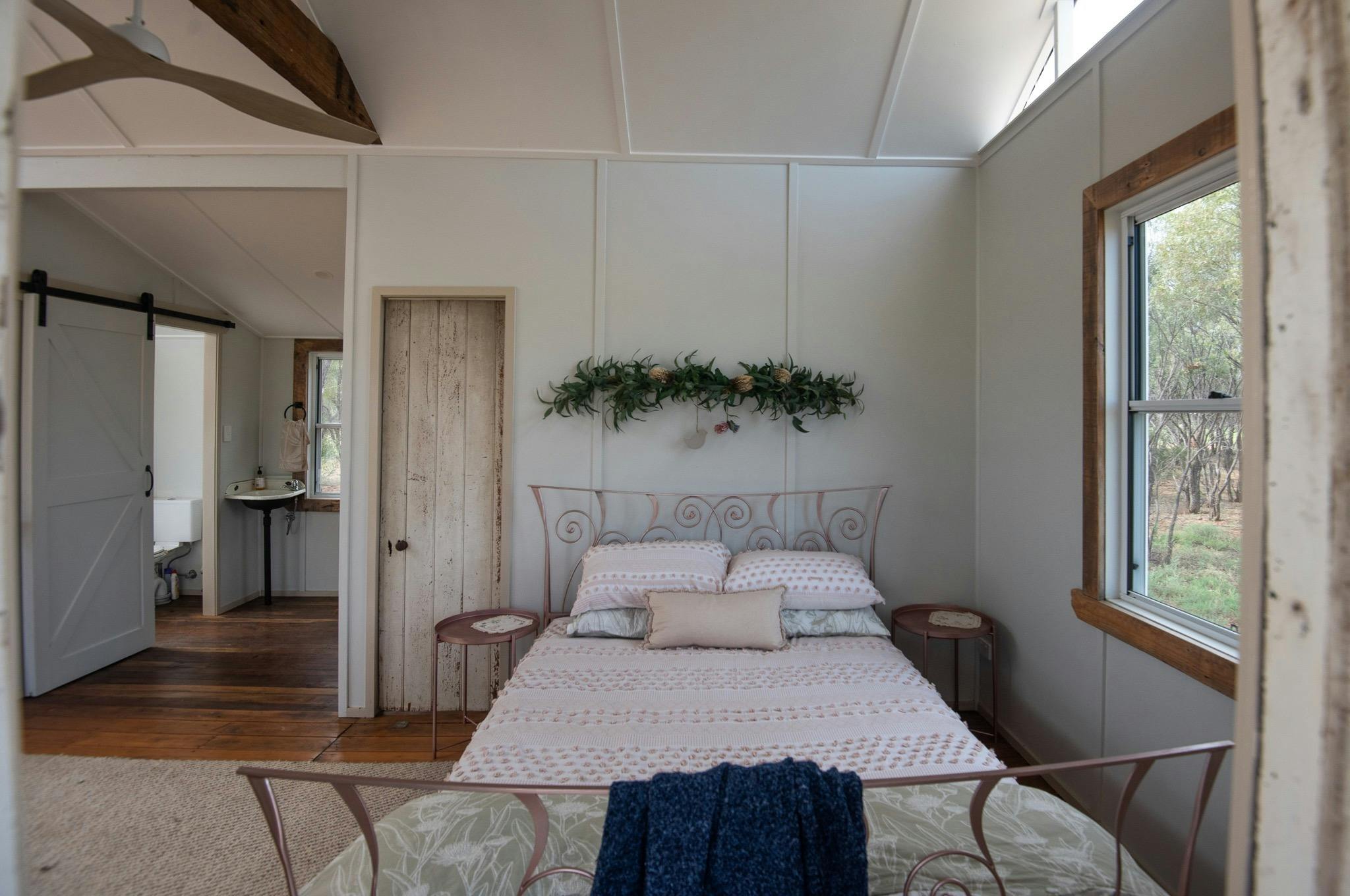 a queen bed inside an open plan cottage