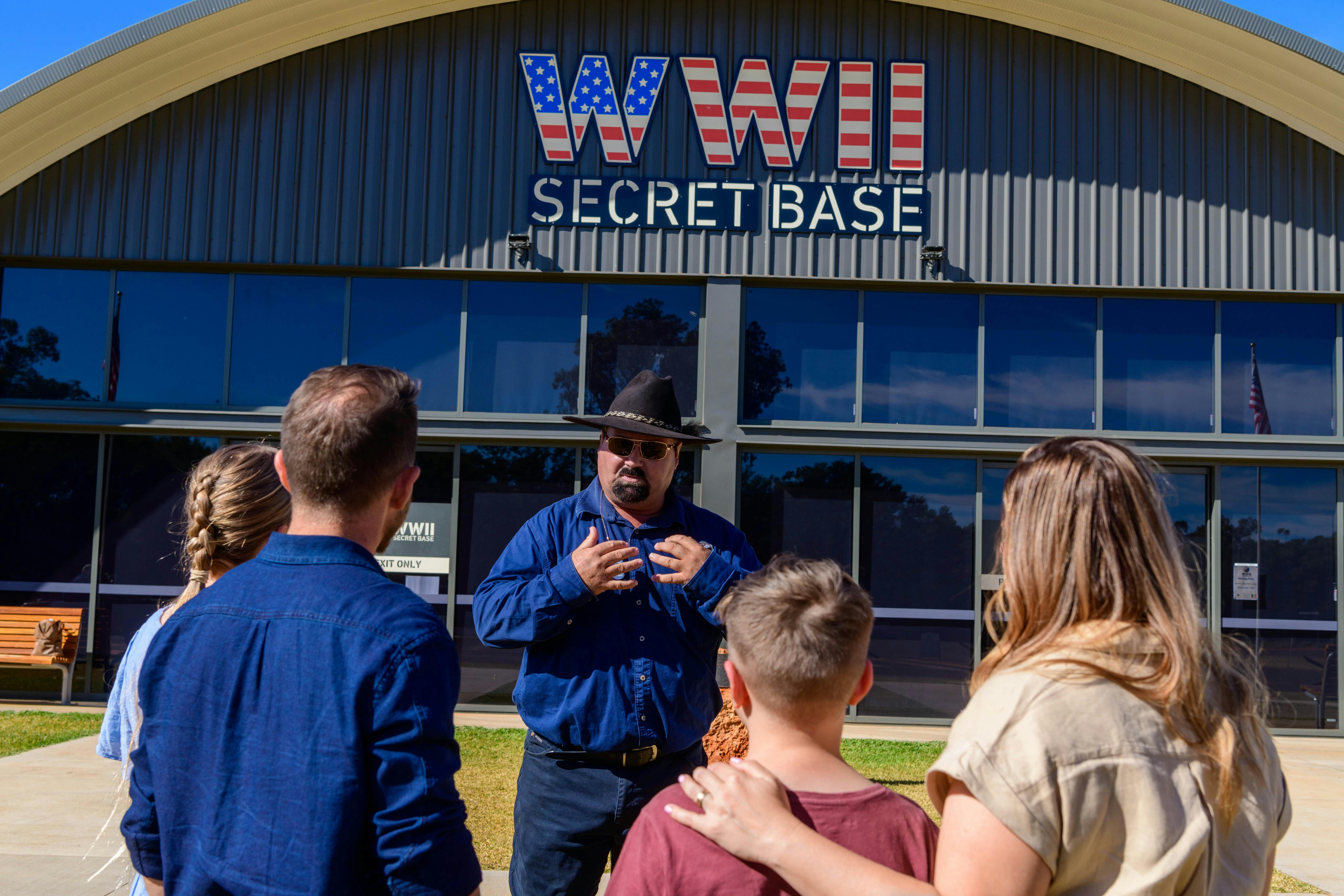 a family of four with a tour guide in front of the Secret Base building at the beginning their tour