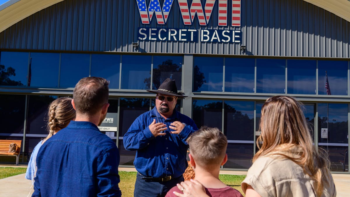 a family of four with a tour guide in front of the Secret Base building at the beginning their tour