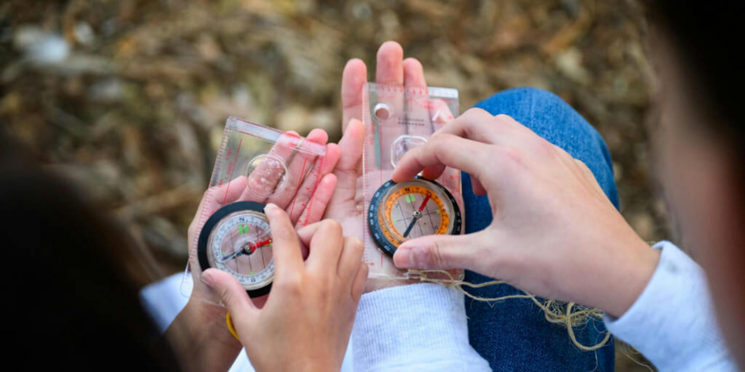 Children's hands holding compasses