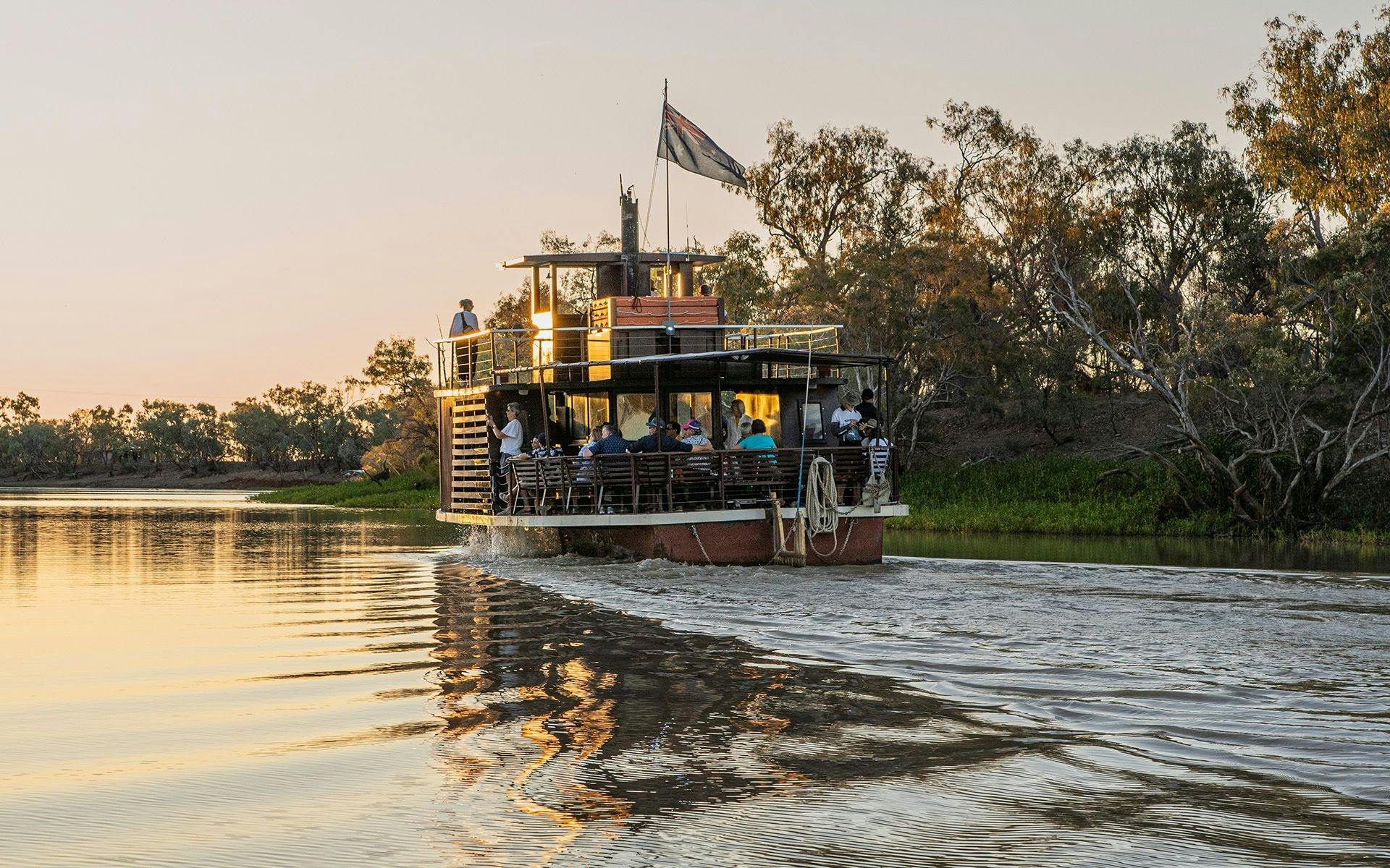 A boat drifting through the Thomson River at sunset