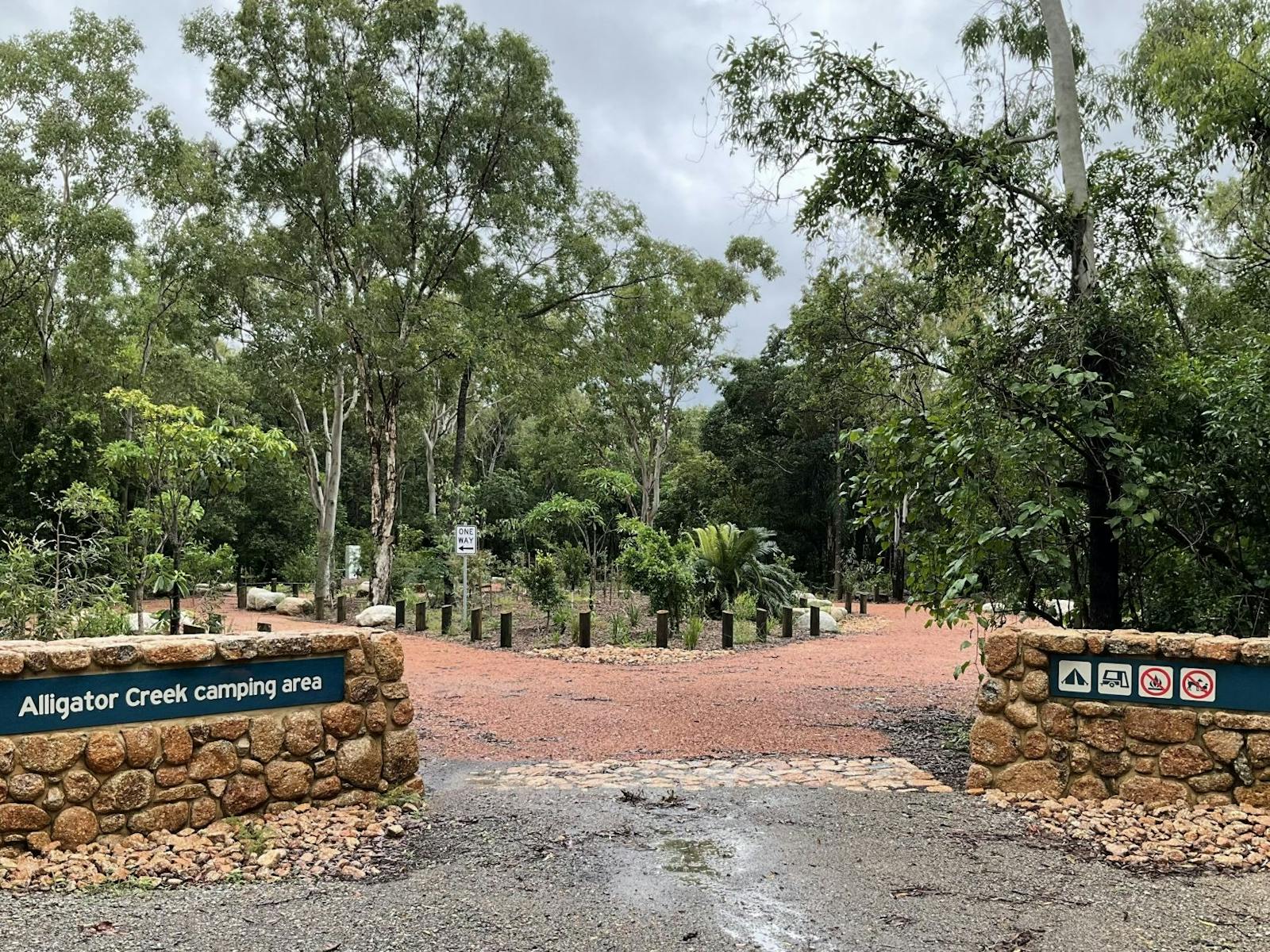The entrance to the camping area showing rock walls with park signs and a forested area beyond The entrance to the camping area showing rock walls with park signs and a forested area beyond
