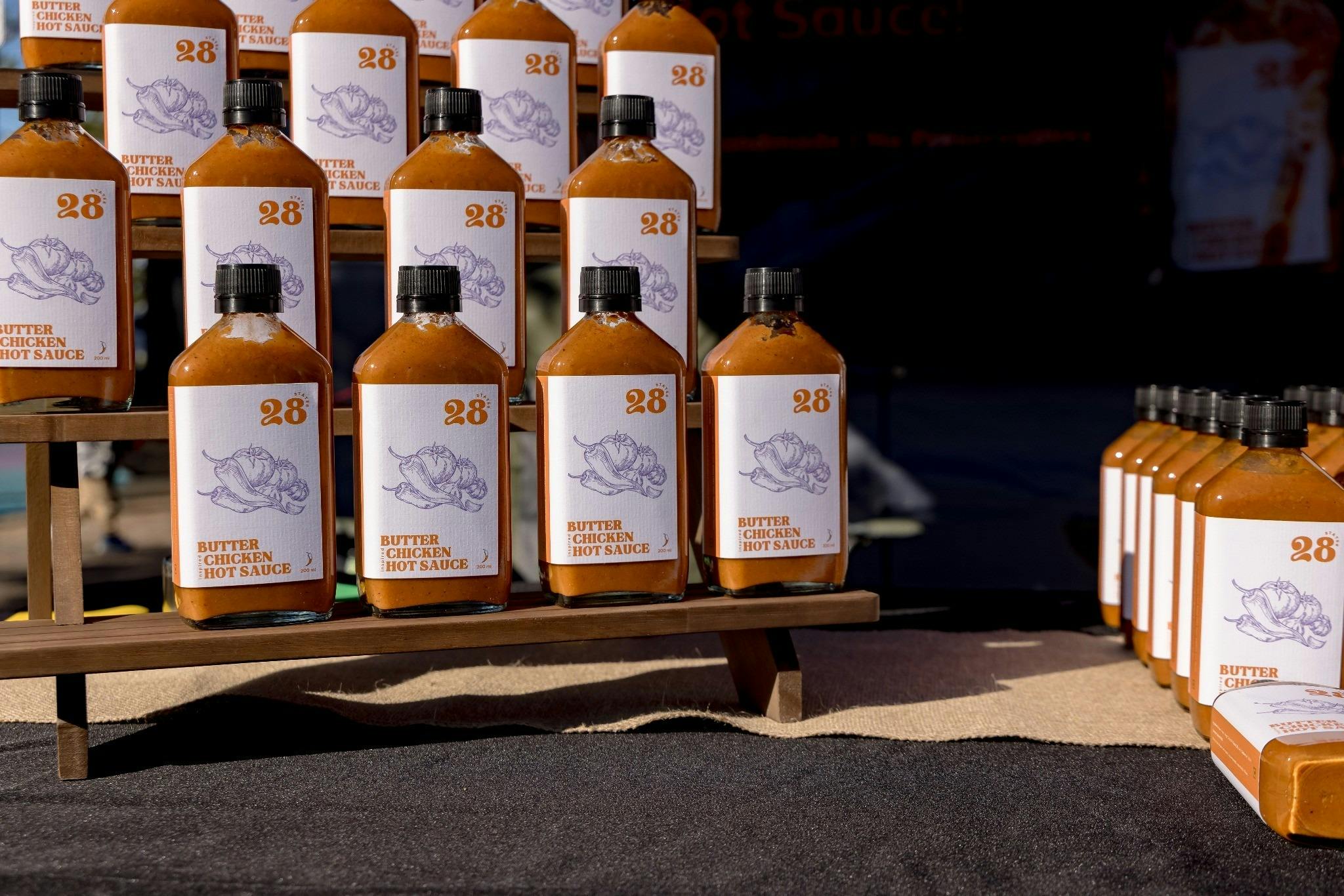 Artisan chilli sauces and hot sauce products on display at a market stall.