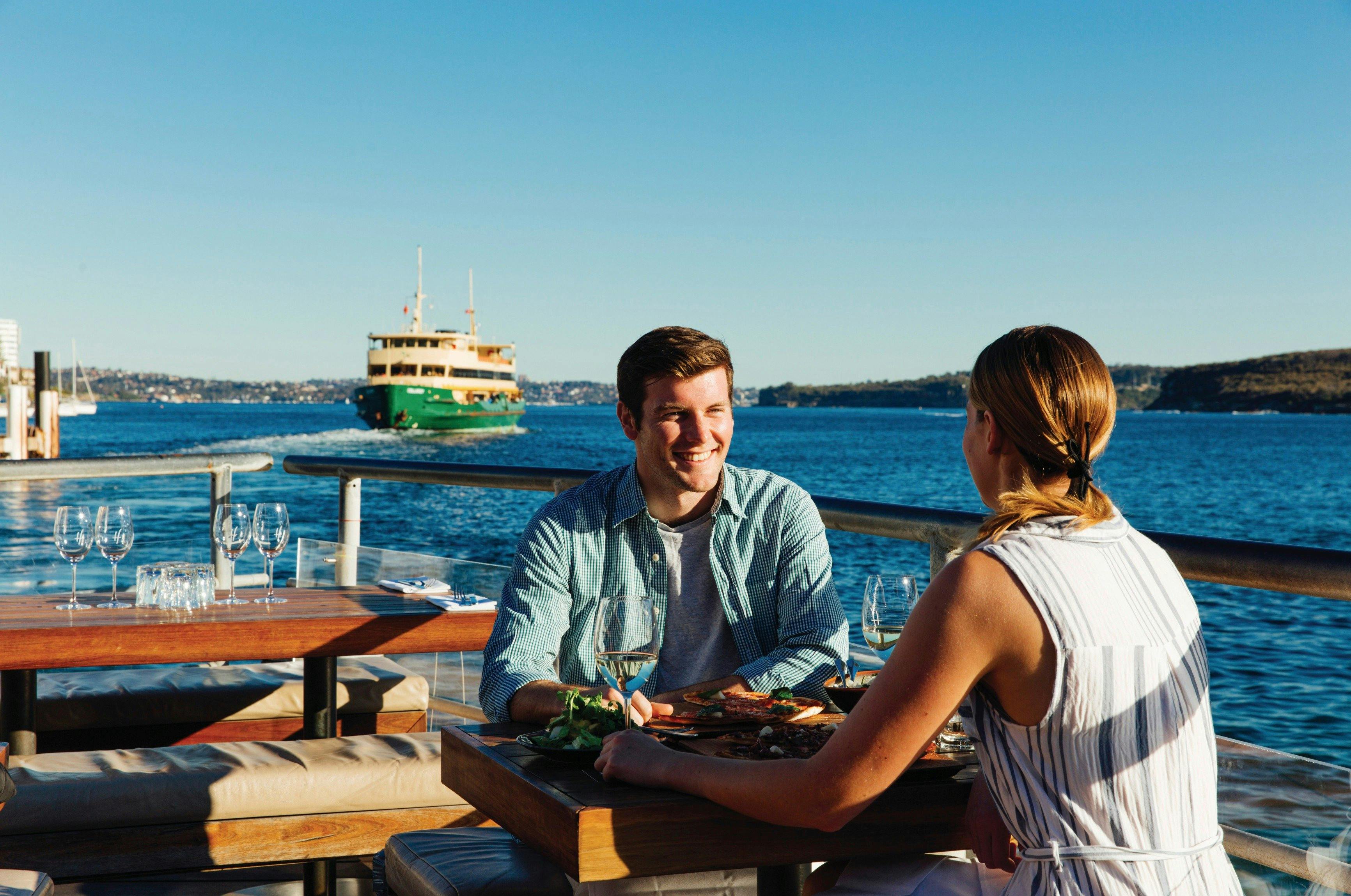 Couple enjoying food and drinks at Hugos Manly, at Manly Wharf