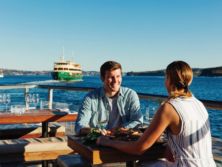 Couple enjoying food and drinks at Hugos Manly, at Manly Wharf