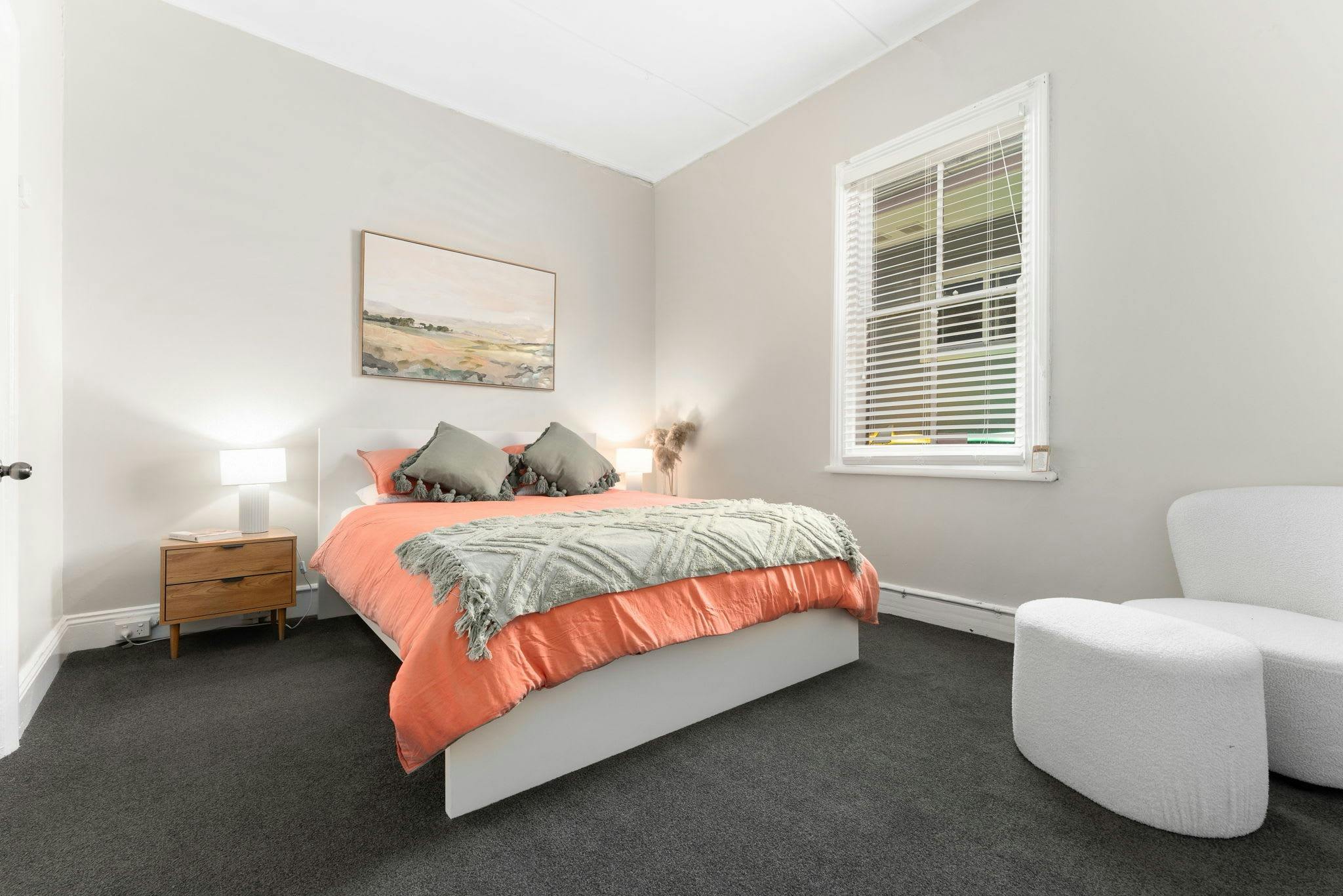 Comfortable queen bed with armchair and window