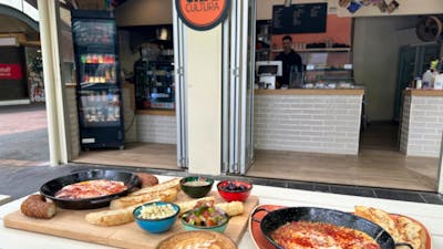 Various Cafe Cultura food offerings positioned on an outdoor table outside the cafe