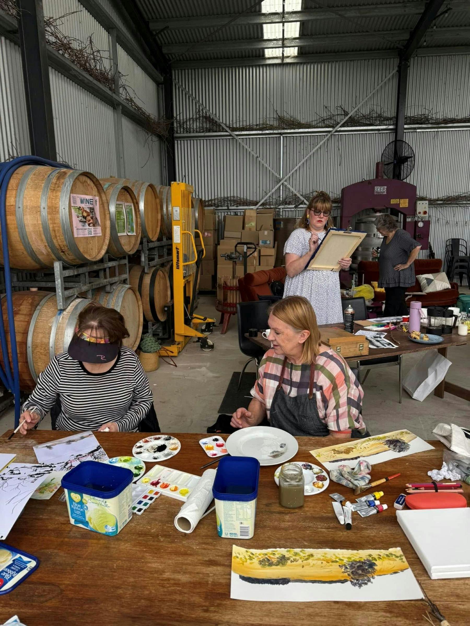 People painting in barrel room